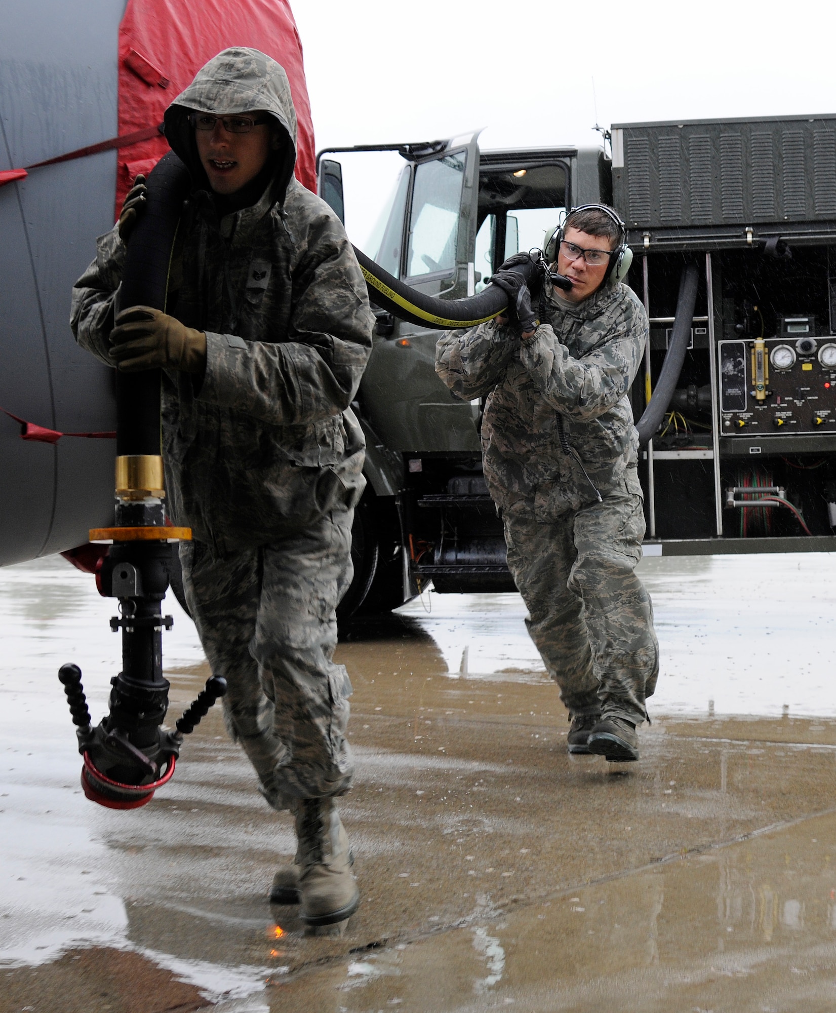 Staff Sgt. Daniel Vergun, 127th Logistics Readiness Squadron fuels technician, and Staff Sgt. Jesse Torma, 191 Maintenance Squadron crew chief, carry the fuel hose to a KC-135 Stratotanker on the flightline at Selfridge Air National Guard Base, Mich., July 9, 2015. Fully loaded, a KC-135 can hold up to 203,000 pounds of fuel. On a typical day, the average load is around 40,000 pounds or 5,900 gallons of fuel. (U.S. Air National Guard Photo by Senior Airman Ryan Zeski/Released)