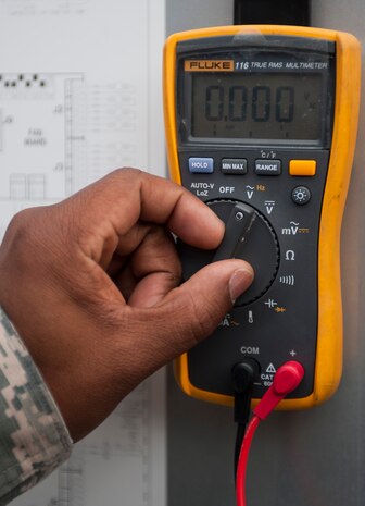 Tech. Sgt. Michael Anderson, 99th Civil Engineer Squadron heating, ventilation, air conditioning and refrigeration craftsman, prepares to check the voltage on an A/C unit at the 99th CES compound on Nellis Air Force Base, Nev., July 7, 2015. The meter measures temperature, micro amps and more, and also has a function that helps prevent false readings. (U.S. Air Force photo by Airman 1st Class Mikaley Towle)
