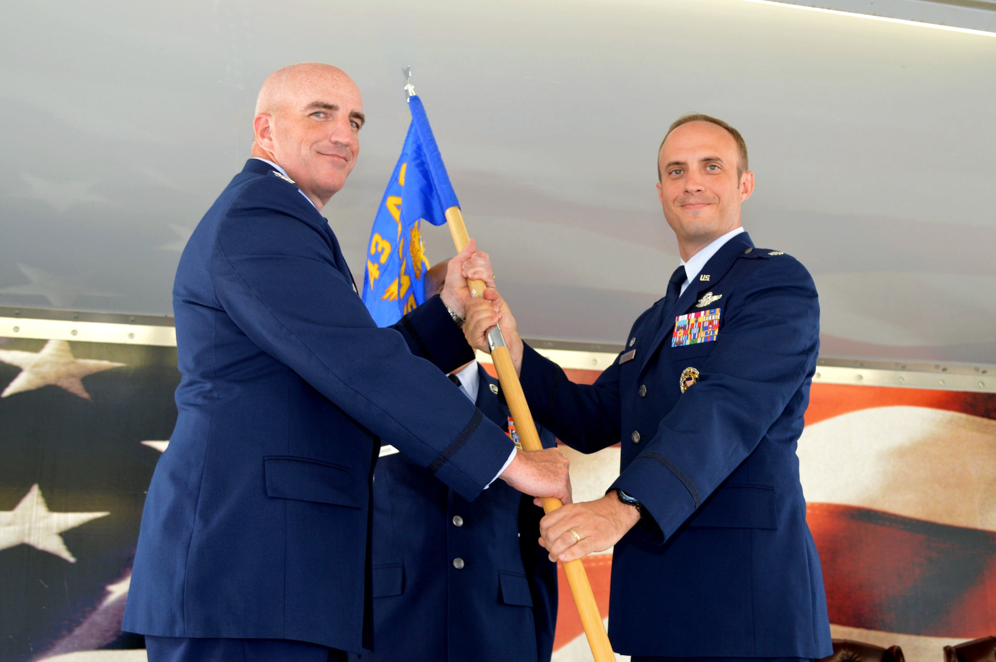 Col. Kenneth Moss, 43rd Airlift Group commander, left, passes the 43rd Air Mobility Squadron guidon to Lt. Col. David Morgan during the 43rd Air Mobility Squadron activation ceremony July 1, 2015, at Pope Army Airfield, North Carolina. Morgan assumed command of the newly established squadron composed of aircraft maintenance and aerial port Airmen and functions transferred from the inactivated 43rd Aircraft Maintenance Squadron and the 3rd Aerial Port Squadron. (U.S. Air Force photo/Marvin Krause)