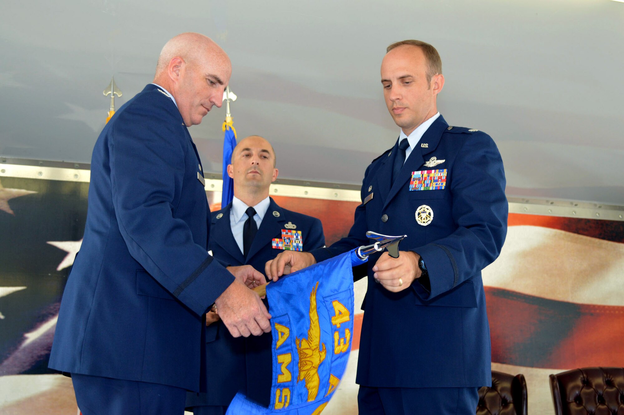 Lt. Col. David Morgan, 43rd Air Mobility Squadron commander, right, and Col. Kenneth Moss, 43rd Airlift Group commander, unfurl the 43rd Air Mobility Squadron guidon July 1, 2015, during the 43rd AMS activation ceremony at Pope Army Airfield, North Carolina. Morgan assumed command of the newly established squadron composed of aircraft maintenance and aerial port Airmen and functions transferred from the inactivated 43rd Aircraft Maintenance Squadron and the 3rd Aerial Port Squadron. (U.S. Air Force photo/Marvin Krause)