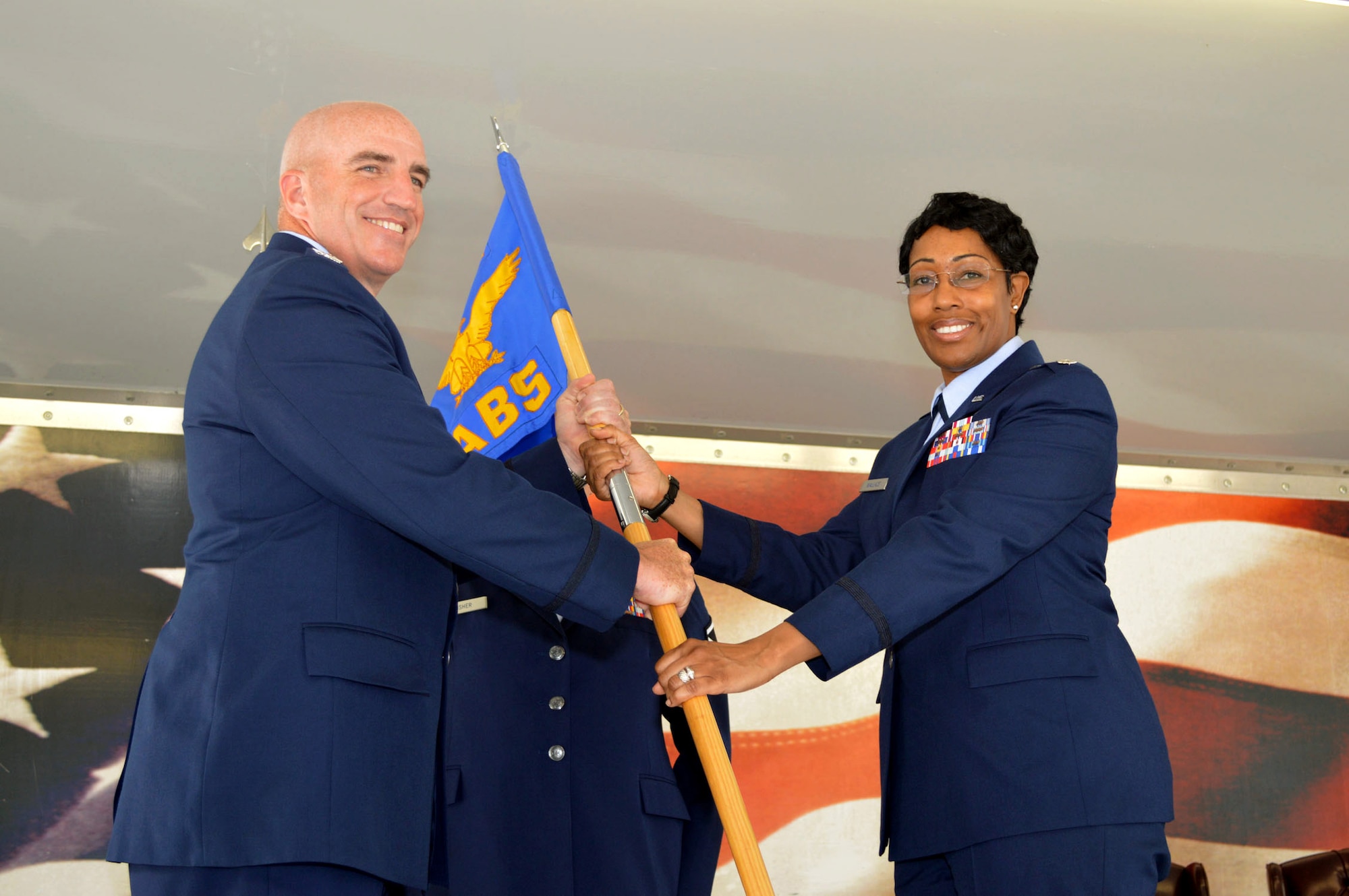 Col. Kenneth Moss, 43rd Airlift Group commander, left, passes the 43rd Air Base Squadron guidon to Lt. Col. Kimberly Wallace during the 43rd Air Base Squadron redesignation and change of command ceremony July 1, 2015, at Pope Army Airfield, North Carolina. Wallace assumed command of the newly established squadron composed of logistics and force support Airmen and functions transferred from the inactivated 43rd Logistics Readiness Squadron and the 43rd Force Support Squadron. (U.S. Air Force photo/Marvin Krause)