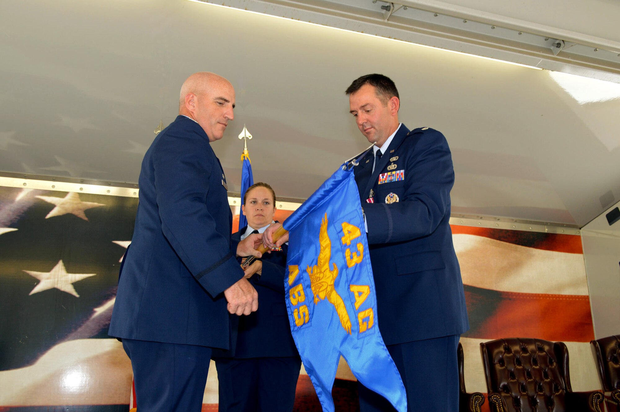 Lt. Col. Brian Ballew, 43rd Force Support Squadron commander, right, and Col. Kenneth Moss, 43rd Airlift Group commander, unfurl the 43rd Air Base Squadron guidon July 1, 2015, during the 43rd ABS redesignation and change of command ceremony at Pope Army Airfield, North Carolina. Force support and logistics Airmen and functions transferred to the newly established 43rd ABS from the inactivated 43rd Logistics Readiness Squadron and the 43rd FSS. (U.S. Air Force photo/Marvin Krause)