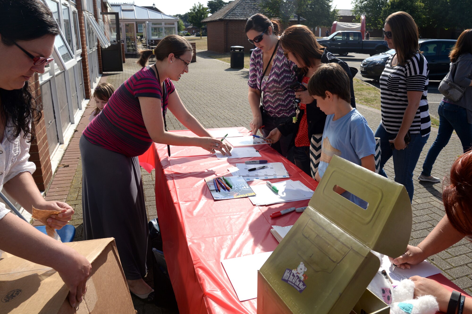 Team Mildenhall families arrive at a Hearts Apart event July 9, 2015, hosted by the 352nd Special Operations Wing on RAF Mildenhall, England. This occasion featured a movie and movie-related door-prizes. The base holds Hearts Apart events on a monthly basis for families of deployed Airmen. (U.S. Air Force photo by Senior Airman Kate Thornton/Released)