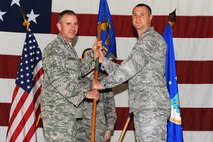 Col. Raymund M. Tembreull, 91st Security Forces Group commander, turns over command of the 91st Security Support Squadron to Capt. Michael J. Kennedy during a change of command ceremony, July 10, 2015. The change of command ceremony is one of the Air Force’s time-honored traditions. (U.S. Air Force photo/Senior Airman Kristoffer Kaubisch)