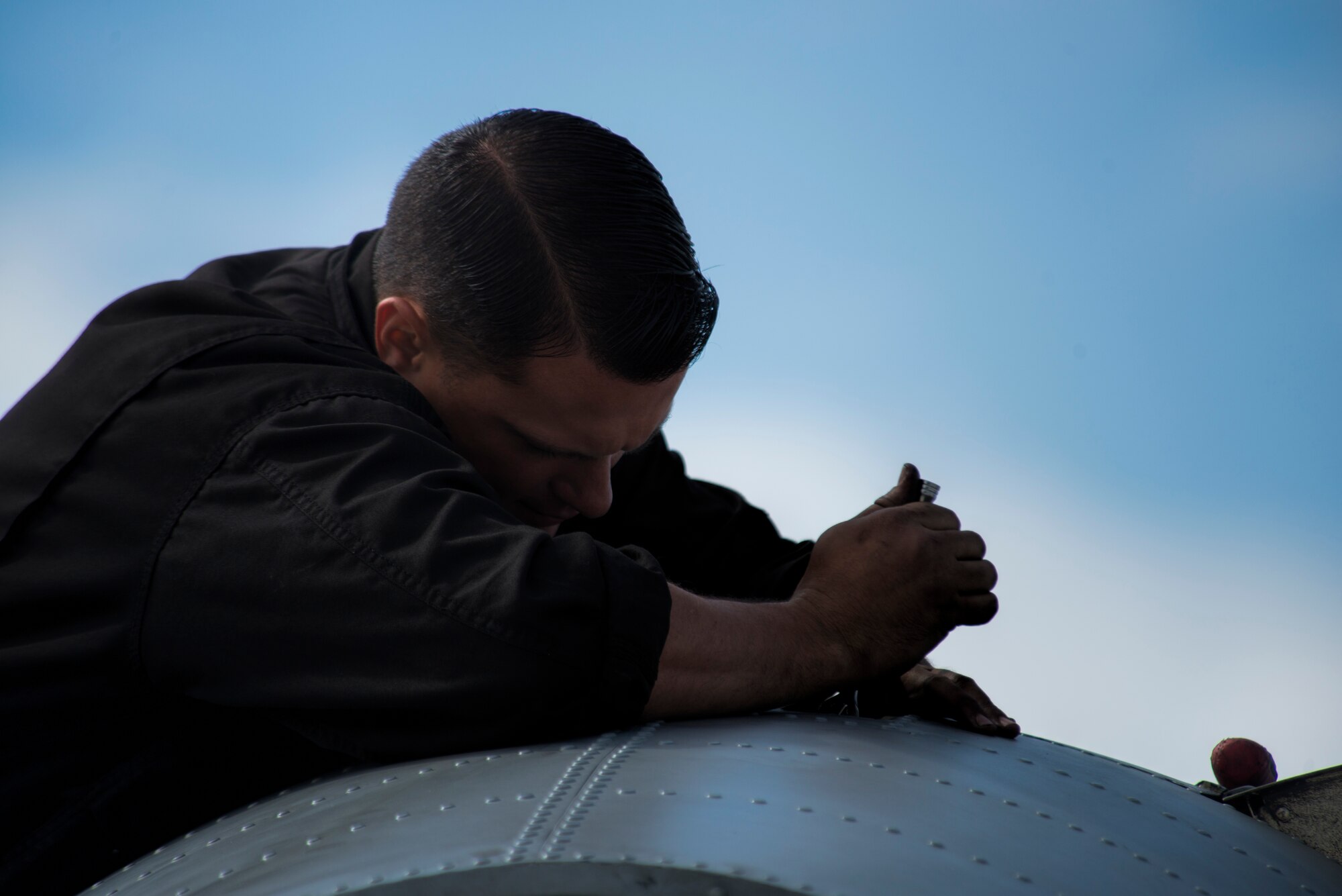 A U.S. Air Force 354th Expeditionary Fighter Squadron crew chief secures a bolt on the engine of a U.S. Air Force A-10 Thunderbolt II attack aircraft during a theater security package deployment to Lask Air Base, Poland, July 9, 2015. U.S. Air Force Airmen conduct training alongside NATO allies to strengthen interoperability and demonstrate U.S. commitment to the security and stability of Europe. (U.S. Air Force photo by Staff Sgt. Christopher Ruano/Released)