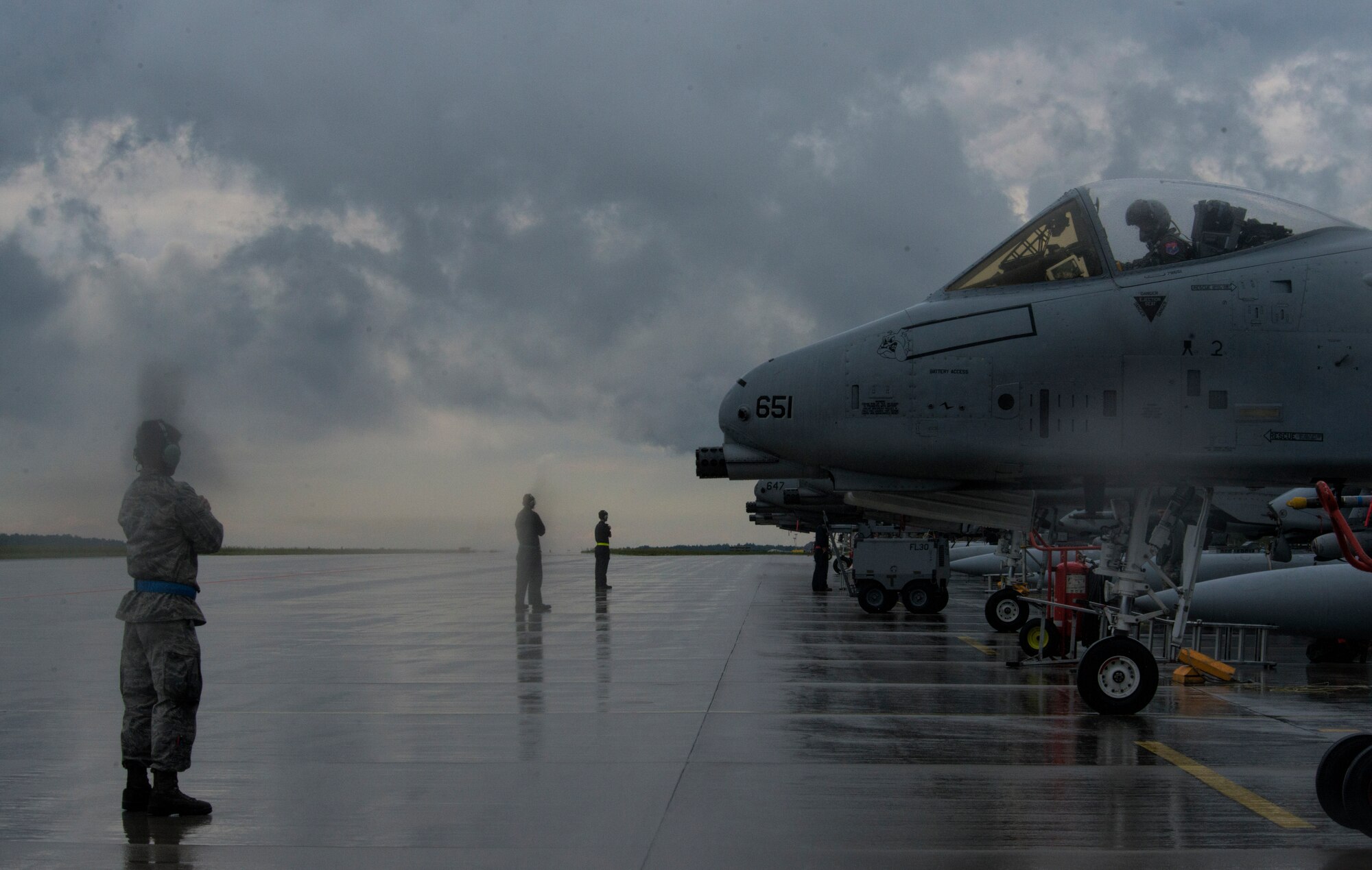 U.S. Air Force crew chiefs from the 354th Expeditionary Fighter Squadron prepare to marshal U.S. Air Force A-10 Thunderbolt II attack aircraft to the taxi way during a theater security package deployment to Lask Air Base, Poland, July 9, 2015. The A-10 supports U.S. Air Force missions around the world as part of its current inventory of strike platforms, including F-15 Eagle and F-16 Fighting Falcon fighter aircraft as part of the TSP. (U.S. Air Force photo by Staff Sgt. Christopher Ruano/Released)