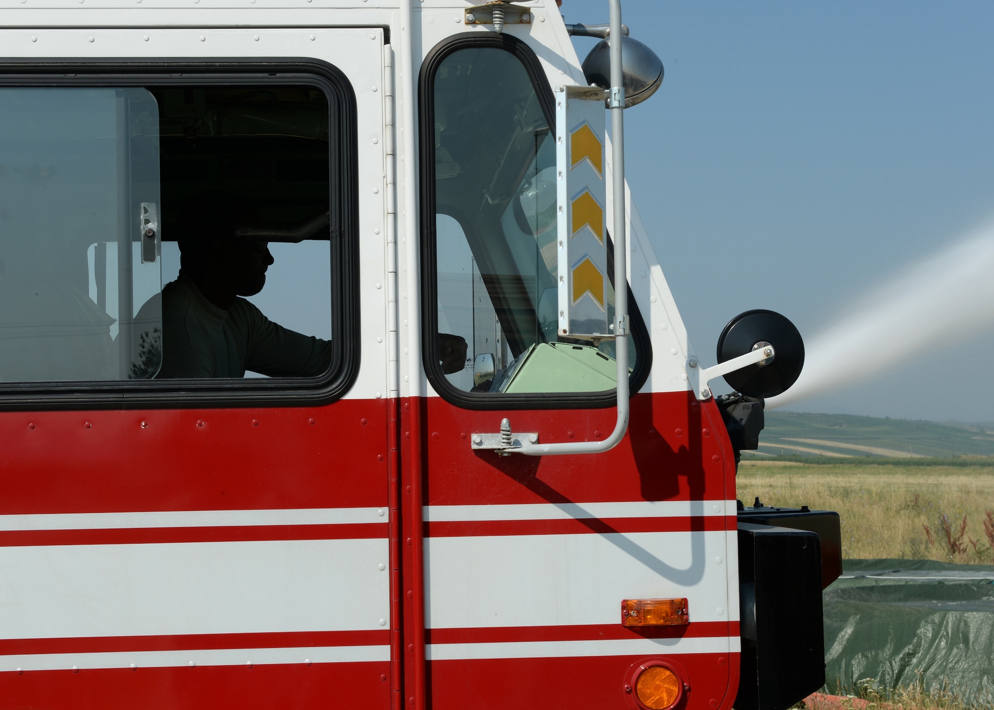A U.S. Air Force fire protection Airman assigned to the 123rd Expeditionary Fighter Squadron performs a turret operation check on the flightline during a theater security package July 8, 2015, at Campia Turzii, Romania. Fire protection Airmen perform daily checks to ensure their equipment is operational to respond to any flightline emergency. (U.S. Air Force photo by Senior Airman Dylan Nuckolls/Released)