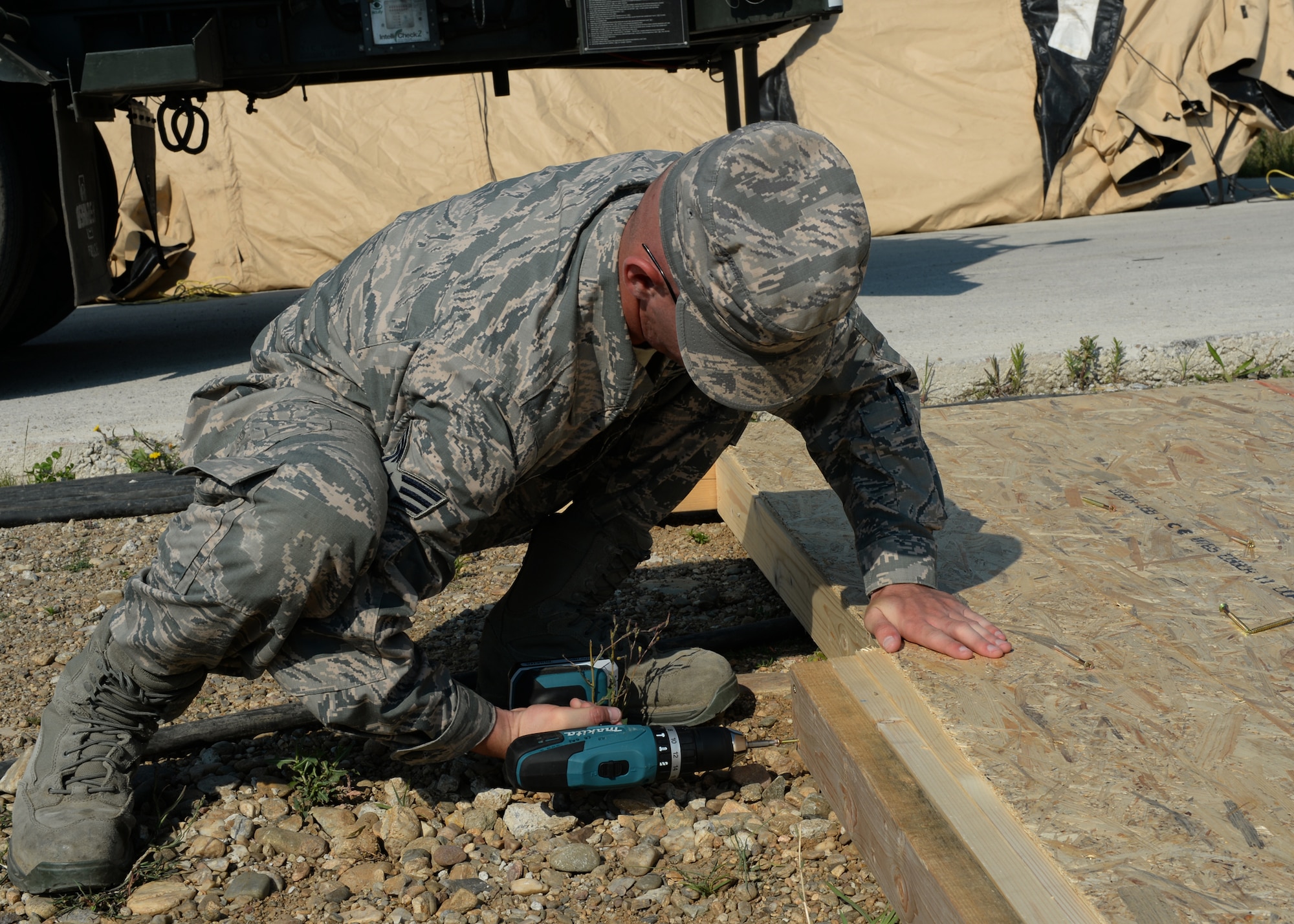 A U.S. Air Force civil engineer Airman assigned to the 123rd Expeditionary Fighter Squadron secures support on a work center awning during a theater security package July 8, 2015, at Campia Turzii, Romania. Airmen from civil engineer squadrons around U.S. Air Forces in Europe major command deployed to Romania to augment TSP packages in Campia Turzii. (U.S. Air Force photo by Senior Airman Dylan Nuckolls/Released)