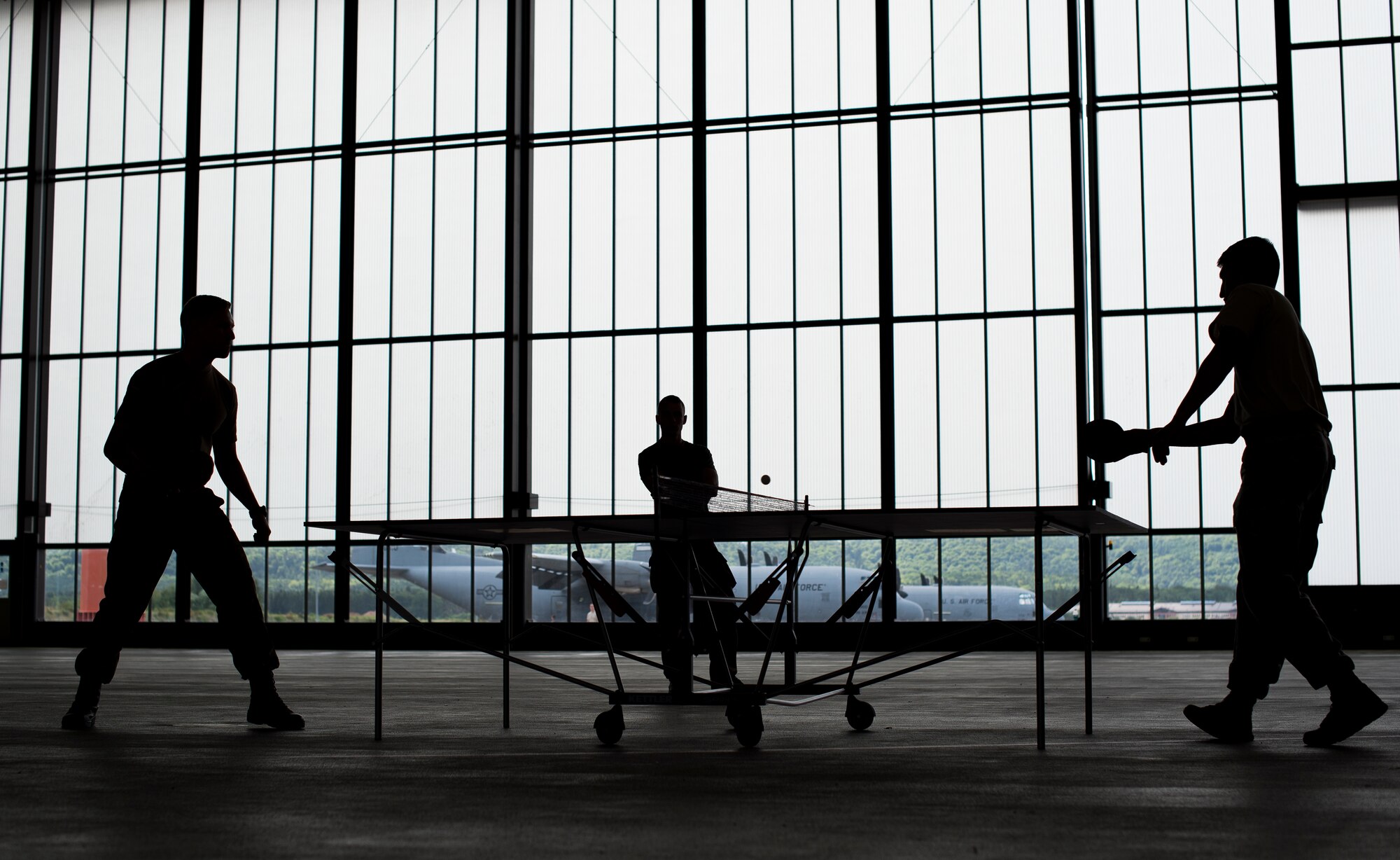 A service member from the U.S. Army and German military members play a game of ping pong during International Jump Week, July 8, 2015 at Ramstein Air Base, Germany. The five-day event gave multiple nations the opportunity to work side-by-side, increasing interoperability and strengthening relationships. (U.S. Air Force photo/Senior Airman Damon Kasberg)