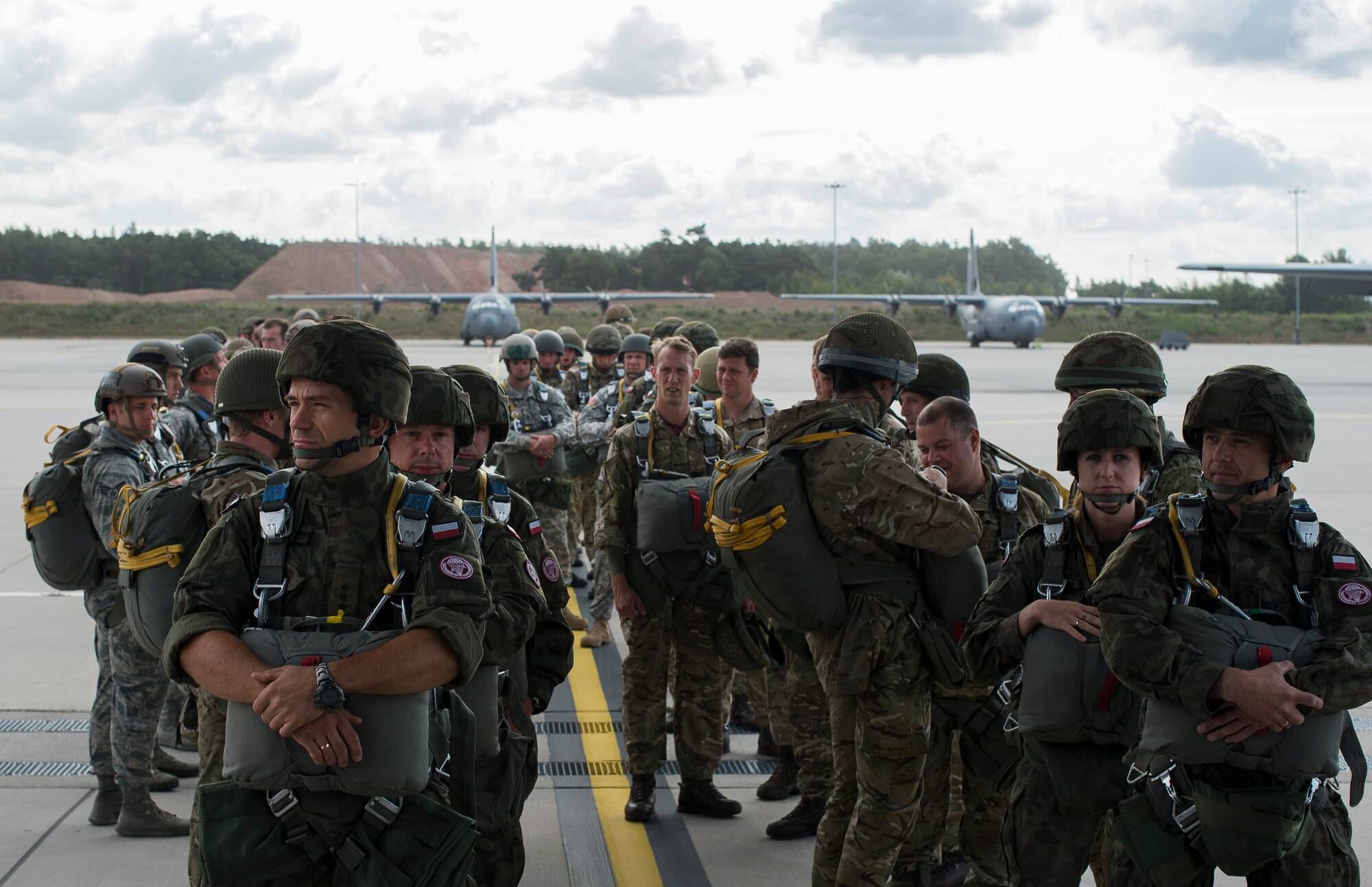 Paratroopers wait to enter a C-130J Super Hercules during International Jump Week, July 8, 2015 at Ramstein Air Base, Germany. Service members throughout Europe and as far a New Zealand traveled to Germany to take part in the five-day event. Every year to culminate the jump training, paratroopers from the allied countries gather for a wing exchange, where they exchange jump wings from fellow paratroopers, signifying the bonds built. (U.S. Air Force photo/Senior Airman Damon Kasberg)