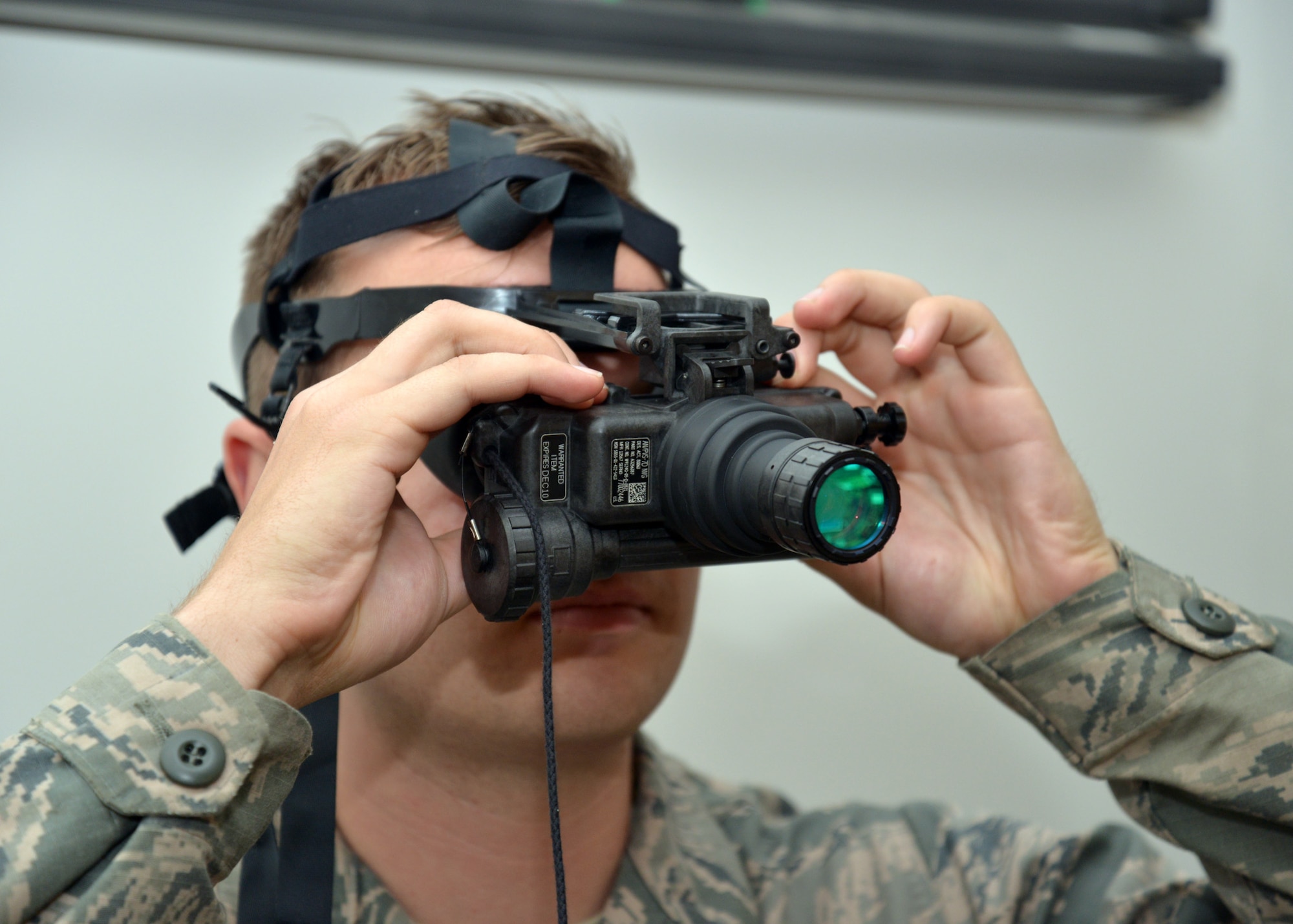 U.S. Air Force Airman Brandon Campbell, 100th Civil Engineer Squadron Power Production apprentice from Santa Rosa, Calif., adjusts the rear diopter rings to focus his night-vision goggles in preparation for night operations training during 100th CES bivouac training June 25, 2015, on RAF Mildenhall, England. Training included team movement techniques, land navigation, use of night-vision goggles and Humvee driving. (U.S. Air Force photo by Karen Abeyasekere/Released)
