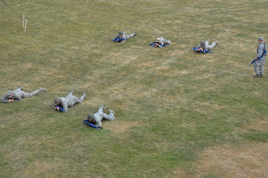 U.S. Air Force Airmen from the 100th Civil Engineer Squadron conduct high crawls during individual movement techniques training under the watchful eye of U.S. Air Force Master Sgt. Joshua Rosenberg, 100th CES Readiness and Emergency Management superintendent from Wichita, Kan., June 25, 2015, on RAF Mildenhall, England. Combat engineers are often called upon to deploy to austere locations and must be able to shoot, move and communicate effectively, and the training helps prepare them for all eventualities. (U.S. Air Force photo by Karen Abeyasekere/Released) 