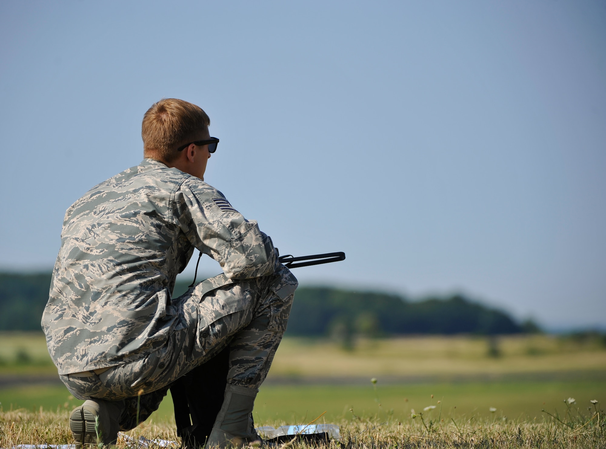 Staff Sgt. Luke Hightower, 435th Contingency Response Group air traffic controller, waits for the estimated drop time of jumpers from a C-130J Super Hercules during International Jump Week near Alzey, Germany, July 7, 2015. Hightower’s responsibility during the event was Drop Zone Safety Officer, monitoring wind speeds and drop zone areas, ensuring the safety of more than 200 paratroopers. (U.S. Air Force photo/Staff Sgt. Leslie Keopka)  