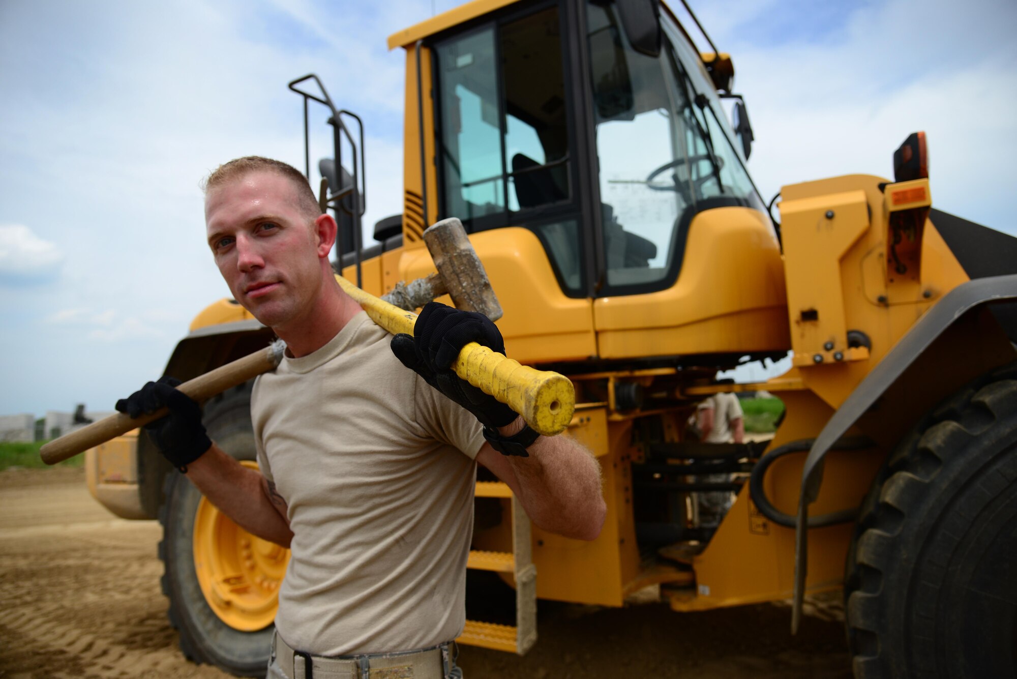 Senior Airman Chad Beasley, 51st Civil Engineer Squadron pavement and construction equipment journeyman, stationed at Osan Air Base, Republic of Korea, poses proudly as a "Dirt Boy" July 10, 2015. Whether coming off of a 12-hour shift, working through the weekend or getting called in at 2 a.m. for an emergency repair, "Dirt Boyz" are the ones working in austere conditions. 
(USAF photo by Staff Sgt. Amber Grimm)