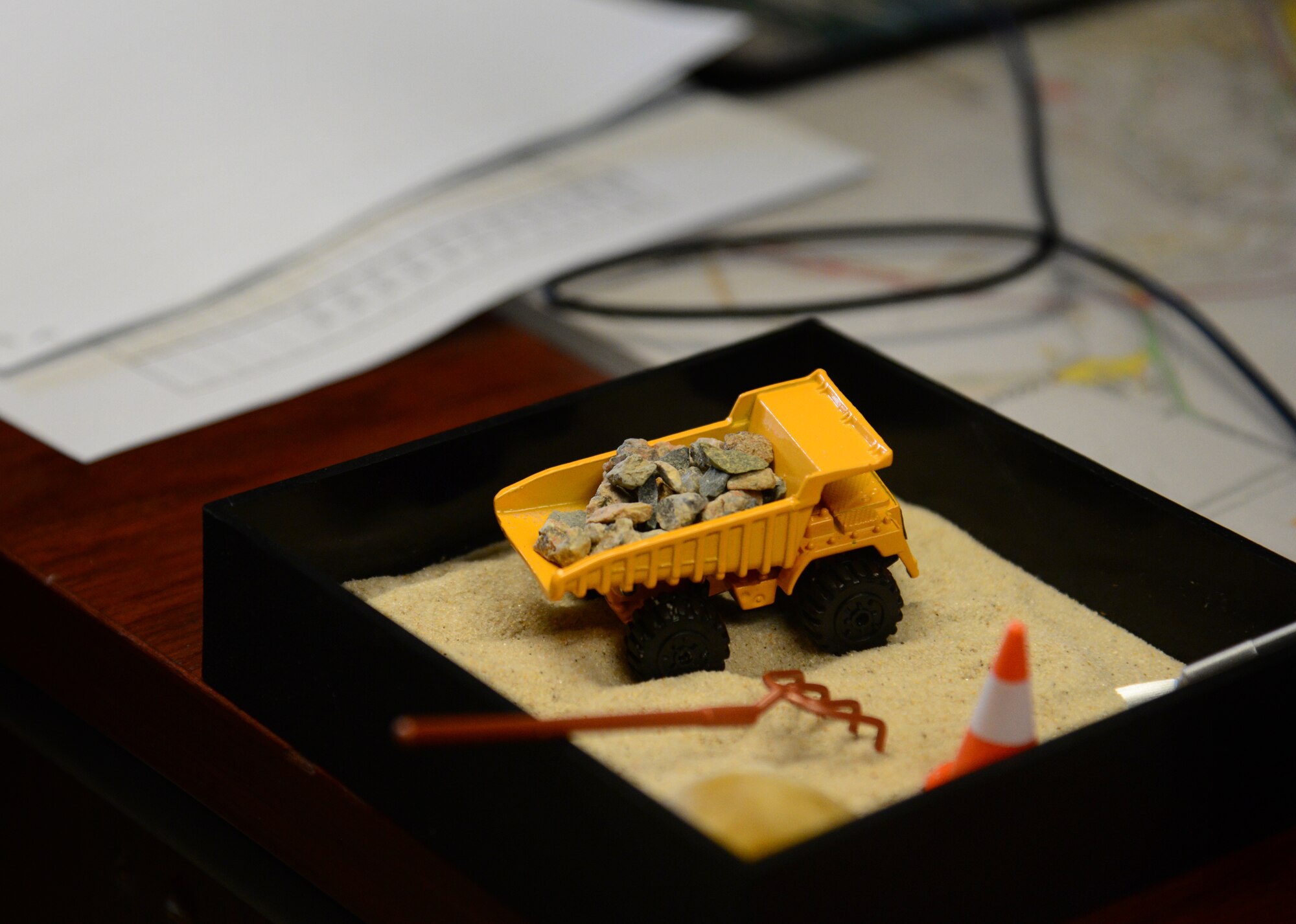 A "Dirt Boyz" version of a Zen rock garden decorates a desk at the 51st Civil Engineer Squadron pavements and construction equipment shop at Osan Air Base, Republic of Korea, July 10, 2015. Whether their sand boxes are big or small a “Dirt Boy” will have the right tool for the job. 
(USAF photo by Staff Sgt. Amber Grimm)