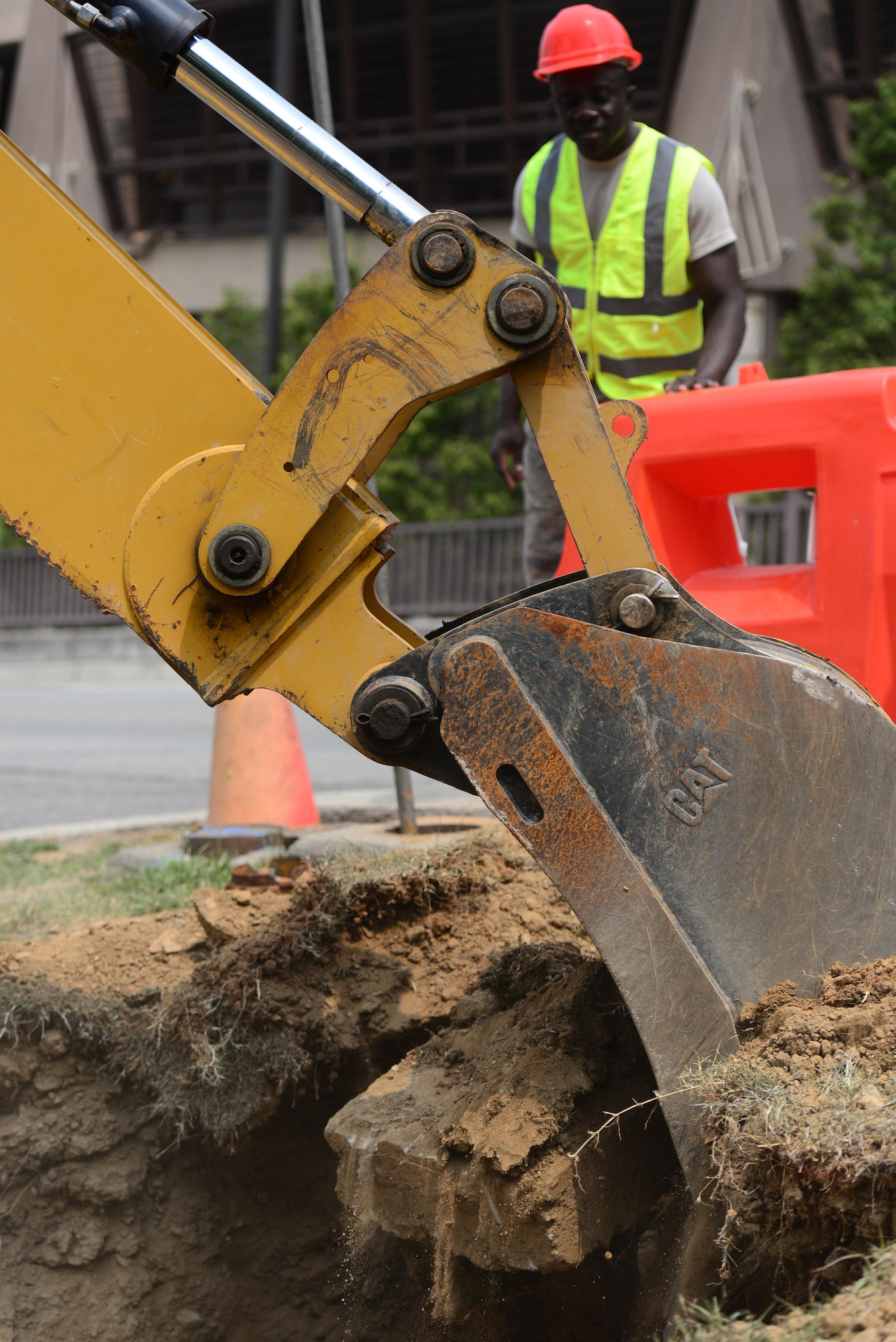 Staff Sgt. Isaac Brenyah, 51st Civil Engineer Squadron pavement and construction equipment craftsman, also known as a "Dirt Boy," directs the use of a backhoe to assist in the removal of an old fire hydrant pipe at Osan Air Base, Republic of Korea, June 24, 2015. As experts in a vast array of heavy machinery the "Boyz" are who the other shops in CES call upon when a project needs to be accomplished. 
(USAF photo by Staff Sgt. Amber Grimm)
