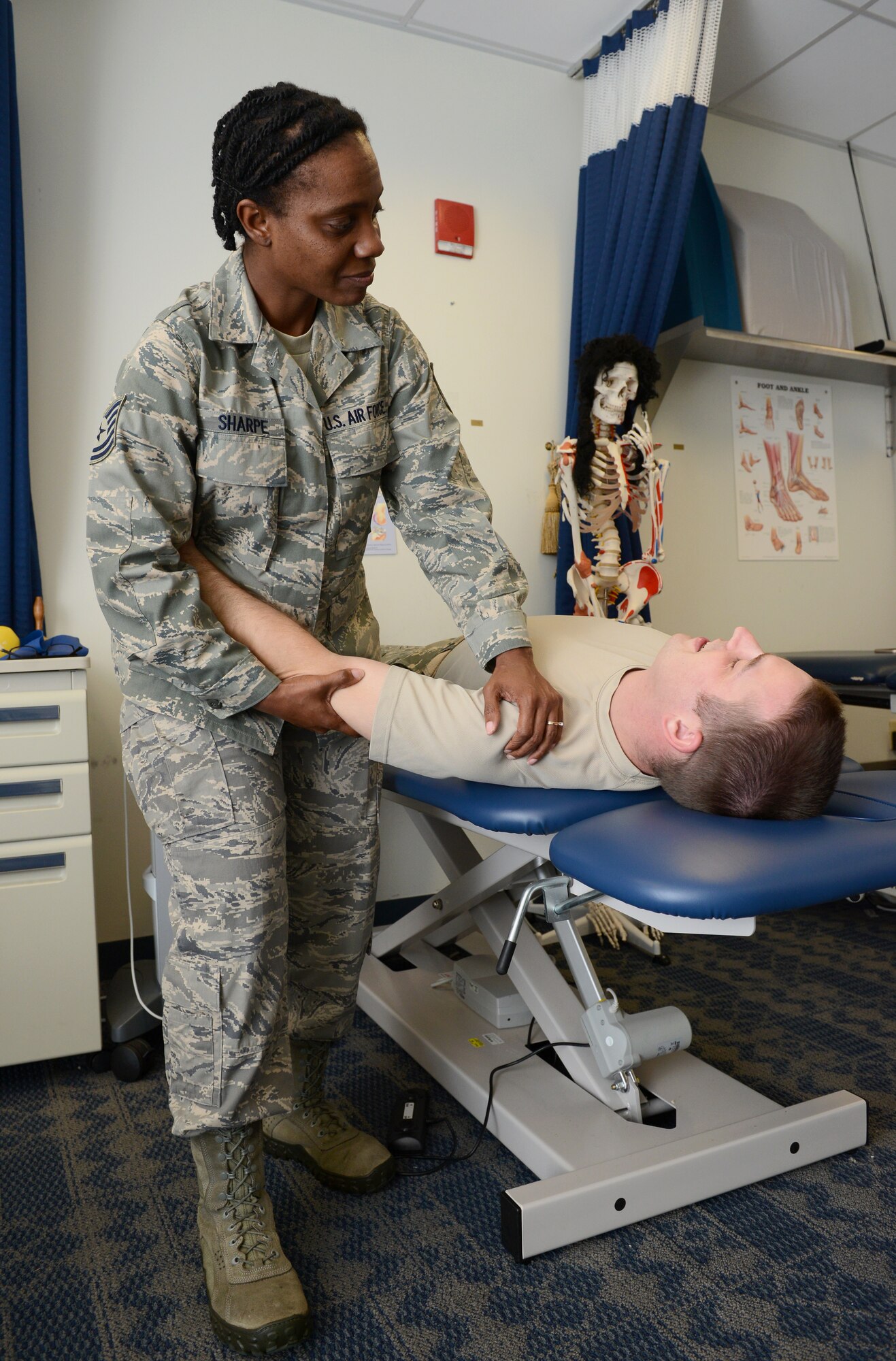 Tech Sgt. Crissy Sharpe, 36th Medical Operations Squadron physical medicine technician, helps Tech. Sgt. George Halley, 36th Contracting Squadron contracting officer, with shoulder mobilization exercises July 8, 2015, at Andersen Air Force Base, Guam. The clinic serves approximately 36 patients a day for musculoskeletal pain and a number of other injuries. (U.S. Air Force photo by Airman 1st Class Arielle Vasquez/Released)