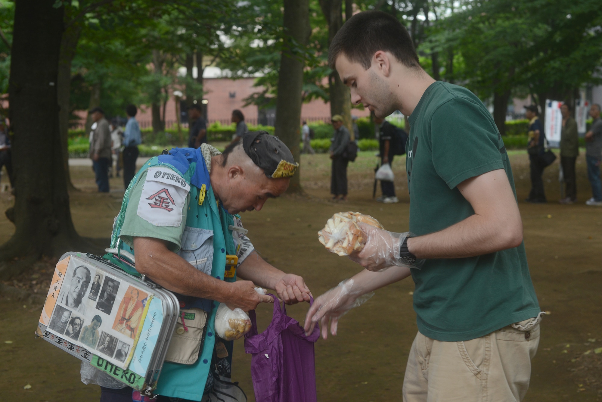 Patrick Cole hands out bread to the homeless at Ueno Park, Tokyo Japan, June 26, 2015. More than 400 people were fed at the homeless outreach event. (U.S. Air Force photo by Airman 1st Class David C. Danford/Released)