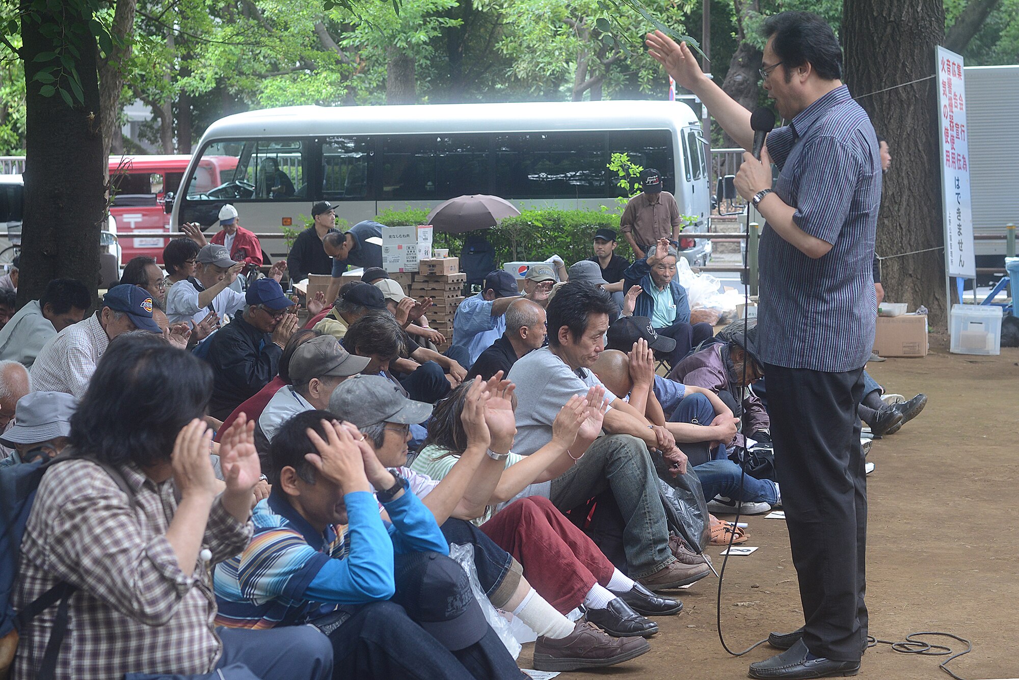 The chaplain of the Homeless Ministry gives a sermon to homeless men and women at Ueno Park, Tokyo Japan, June 26, 2015. The Homeless Ministry holds three to four outreach events each week with Team Yokota members supporting one per month. (U.S. Air Force photo by Airman 1st Class David C. Danford/Released)