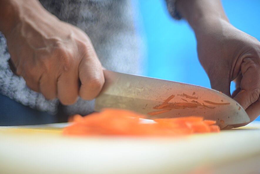 Deborah Goodman cuts carrots used to feed the homeless at Ueno Park, Tokyo Japan, June 26, 2015. The base chapel has received multiple commendations, including the Zenko-Kai award, for their participation in homeless outreach events. (U.S. Air Force photo by Airman 1st Class David C. Danford/Released)