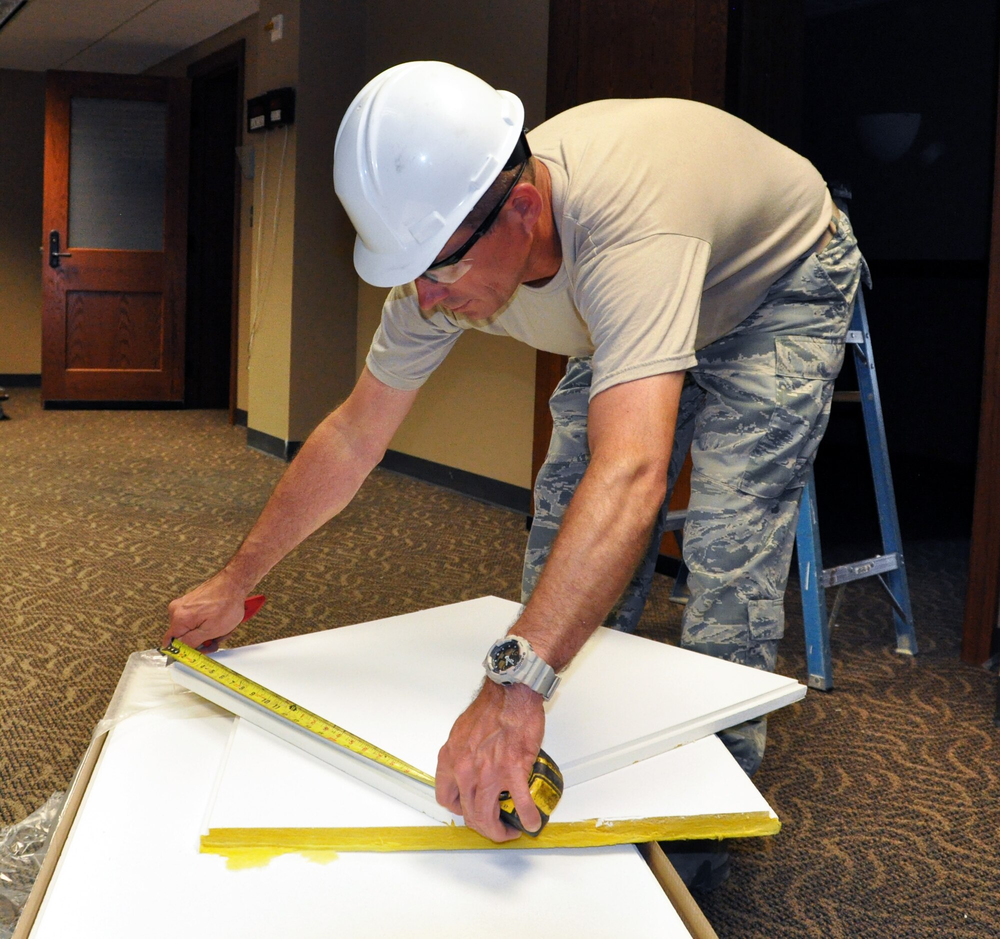 Tech. Sgt. Kevin Toomey, 931st Civil Engineer Squadron, measures a sound dampening ceiling panel before cutting it for installation in Building 1218 at McConnell Air Force Base, Kan., July 11, 2015.  The installation is part of a renovation project on the building, during which 931 CES Airmen have installed both the new ceiling panels as well as new floor tiles. Additionally, over the last two months 931 CES Airmen have made significant contributions to the remodel of Building 1219, to include work in plumbing and heating, ventilating and air conditioning (HVAC).  931 CES Airmen consistently work together with their active duty counterparts from the 22nd Air Refueling Wing to repair and improve the facilities of McConnell Air Force Base.  (U.S. Air Force photo by Capt. Zach Anderson) 