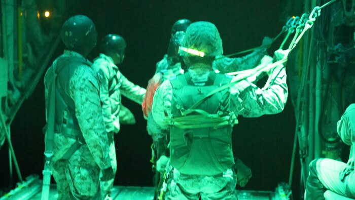 Marines with 1st Radio Battalion, I Marine Expeditionary Force, prepare to conduct a parachute drop out of a KC-130J Super Hercules at Marine Corps Base Camp Pendleton, California, July 8. Marines with Marine Aerial Refueler Transport Squadron (VMGR) 352 assisted the battalion with the parachute drop. 