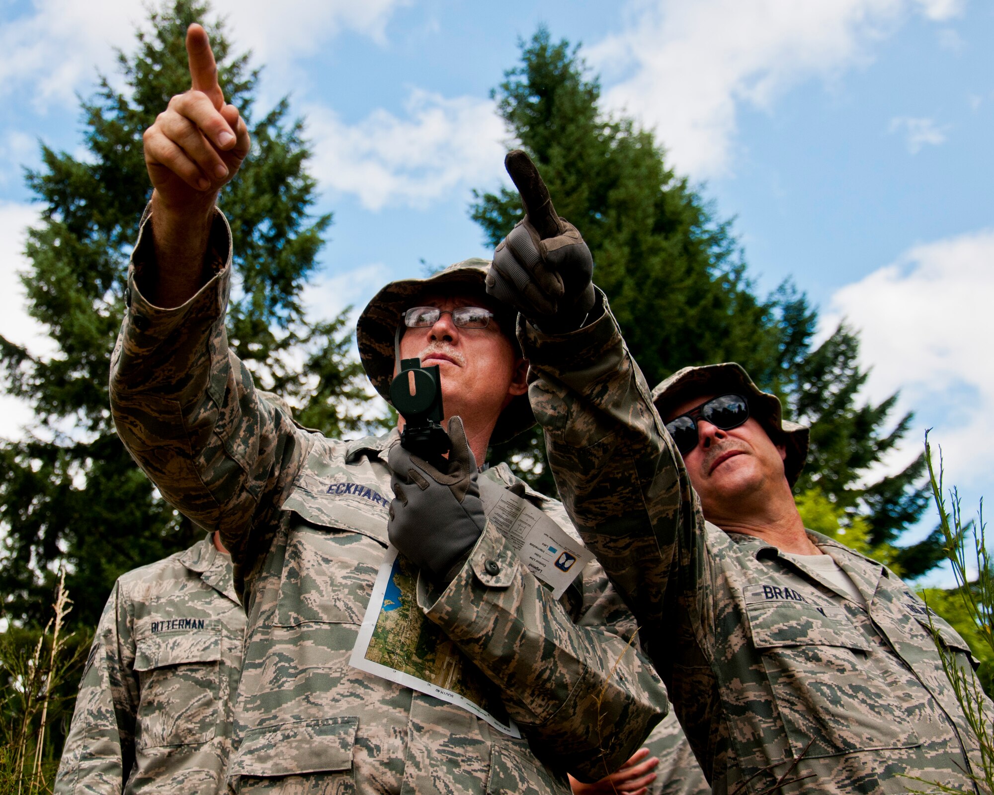 Medics from the 446th Aeromedical Staging Squadron discern which direction to head for land navigation training during the Care Under Fire exercise at Joint Base Lewis-McChord, July 12, 2015.  The Care Under Fire exercise was designed locally by the 446th ASTS in order to simulate combat conditions and establish team oriented training scenarios. Medics were offered land navigation training in order to enhance their combat readiness in austere locations. (U.S. Air Force photo by Senior Airman Daniel Liddicoet/Released)