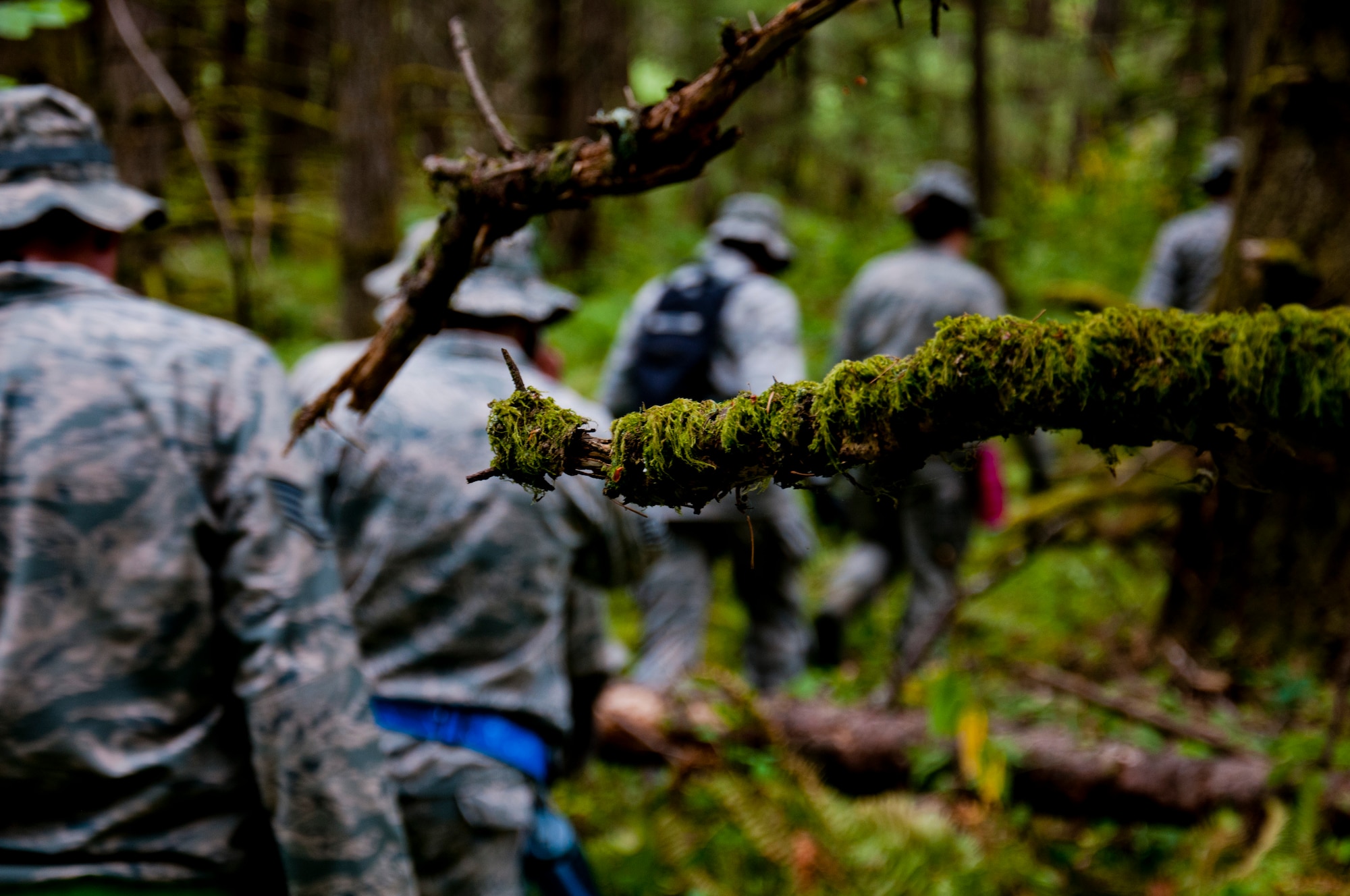 Medics from the 446th Aeromedical Staging Squadron make their way through the woods for the Care Under Fire exercise at Joint Base Lewis-McChord, July 12, 2015.  The Care Under Fire exercise was designed locally by the 446th ASTS in order to simulate combat conditions and establish team oriented training scenarios. Medics were offered land navigation training in order to enhance their combat readiness in austere locations. (U.S. Air Force photo by Senior Airman Daniel Liddicoet/Released)