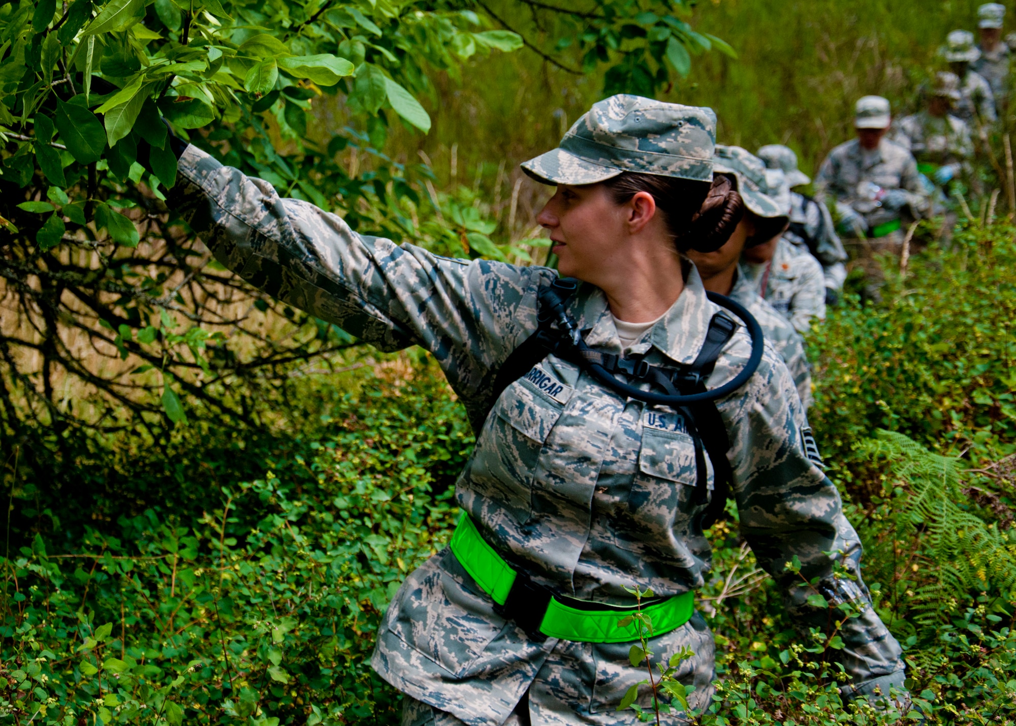 Medics from the 446th Aeromedical Staging Squadron make their way through the woods for the Care Under Fire exercise at Joint Base Lewis-McChord, July 12, 2015.  The Care Under Fire exercise was designed locally by the 446th ASTS in order to simulate combat conditions and establish team oriented training scenarios. Medics were offered land navigation training in order to enhance their combat readiness in austere locations. (U.S. Air Force photo by Senior Airman Daniel Liddicoet/Released)