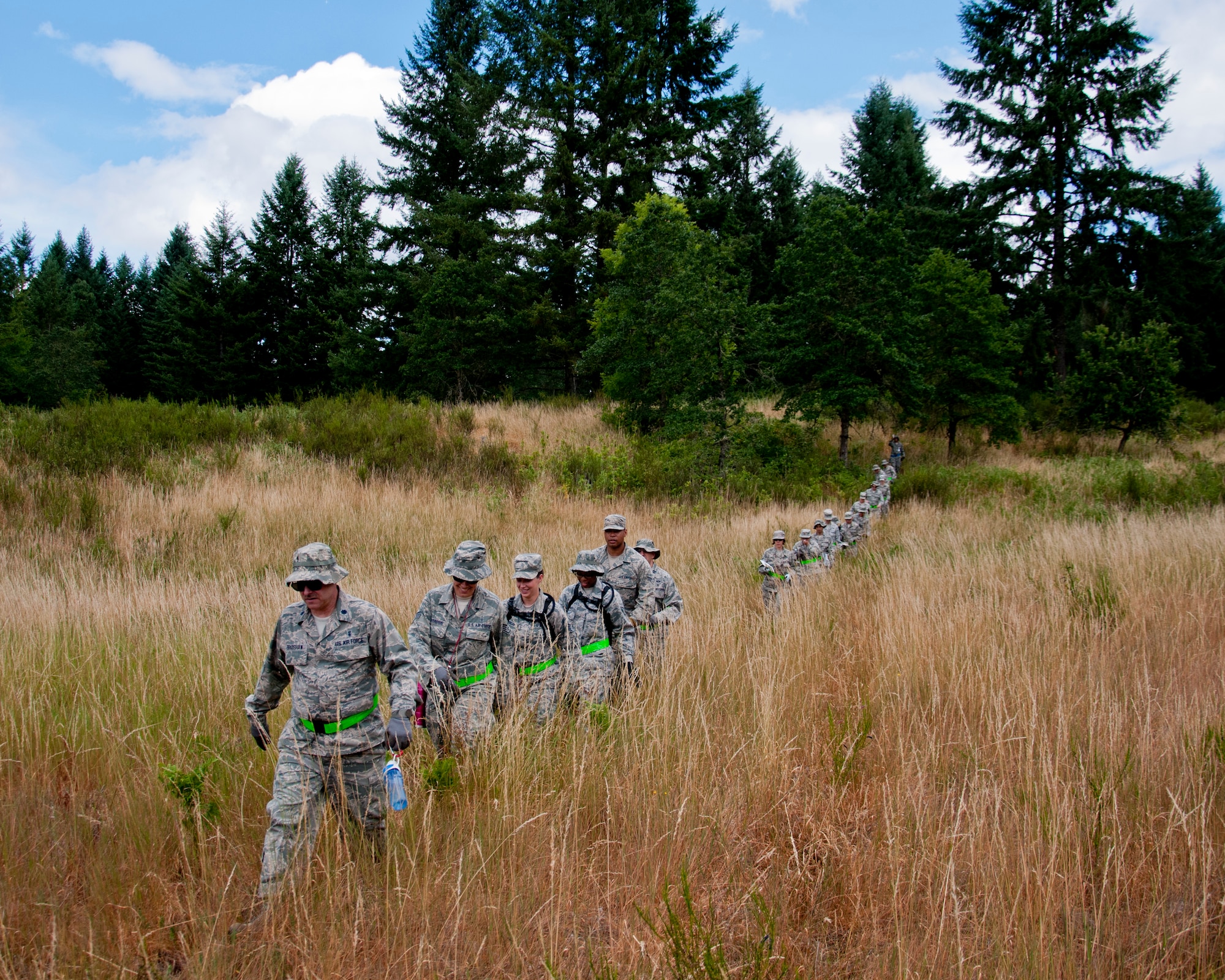 Medics from the 446th Aeromedical Staging Squadron make their way through the woods for the Care Under Fire exercise at Joint Base Lewis-McChord, July 12, 2015.  The Care Under Fire exercise was designed locally by the 446th ASTS in order to simulate combat conditions and establish team oriented training scenarios. Medics were offered land navigation training in order to enhance their combat readiness in austere locations. (U.S. Air Force photo by Senior Airman Daniel Liddicoet/Released)