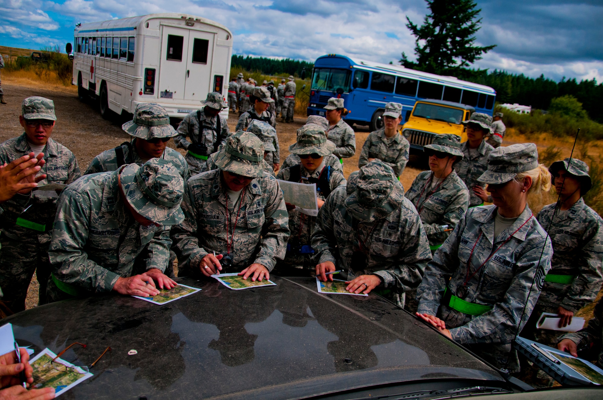 Medics from the 446th Aeromedical Staging Squadron map out their routes during land navigation training for the Care under Fire exercise at Joint Base Lewis-McChord, July 12, 2015.  The Care under Fire exercise was designed locally by the 446th ASTS in order to simulate combat conditions and establish team oriented training scenarios. Medics were offered land navigation training in order to enhance their combat readiness in austere locations. (U.S. Air Force photo by Senior Airman Daniel Liddicoet/Released)