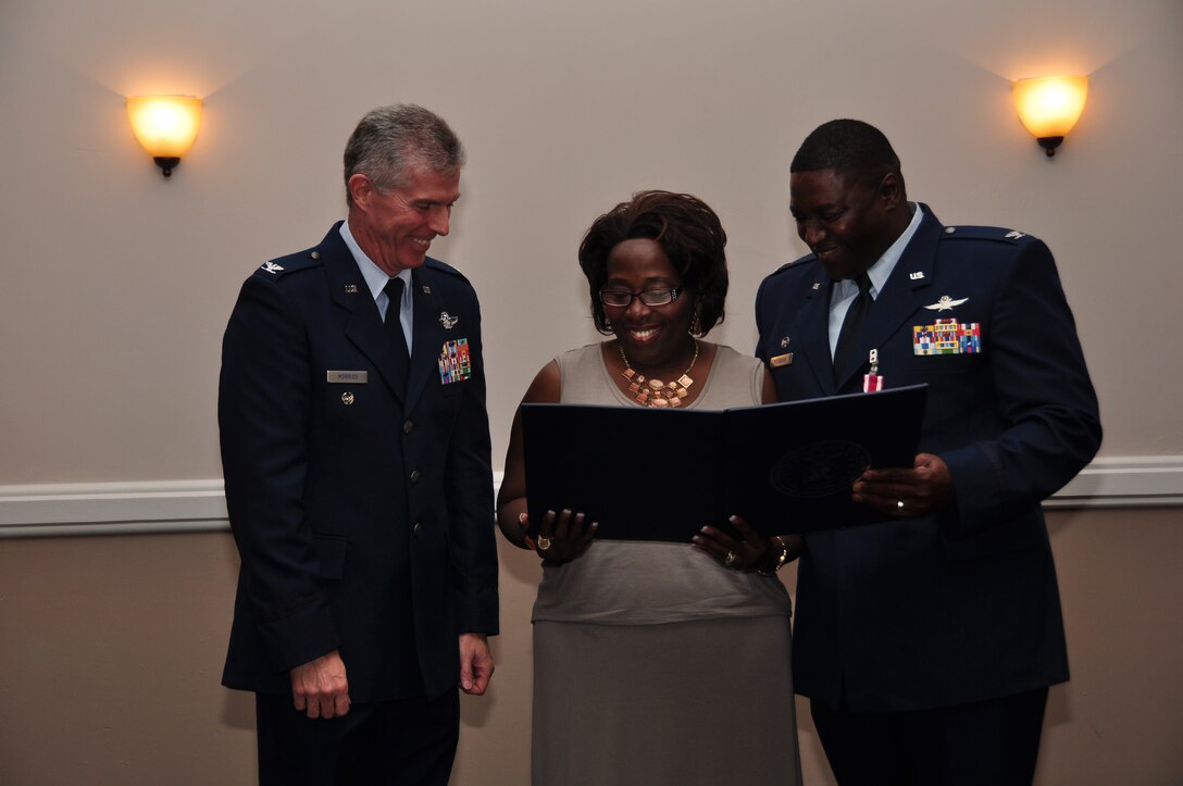 U.S. Air Force Col. James Morriss, 307th Bomb Wing vice commander, presents a certificate of appreciation to Mrs. Jasmine Peterson during her husband’s, Col. Roy Peterson, retirement ceremony on July 11, 2015, at Barksdale Air Force Base, Louisiana. Peterson is the 307th Mission Support Group commander and is retiring after 32 years of military service. (U.S. Air Force photo by Master Sgt. Laura Seibert/Released)