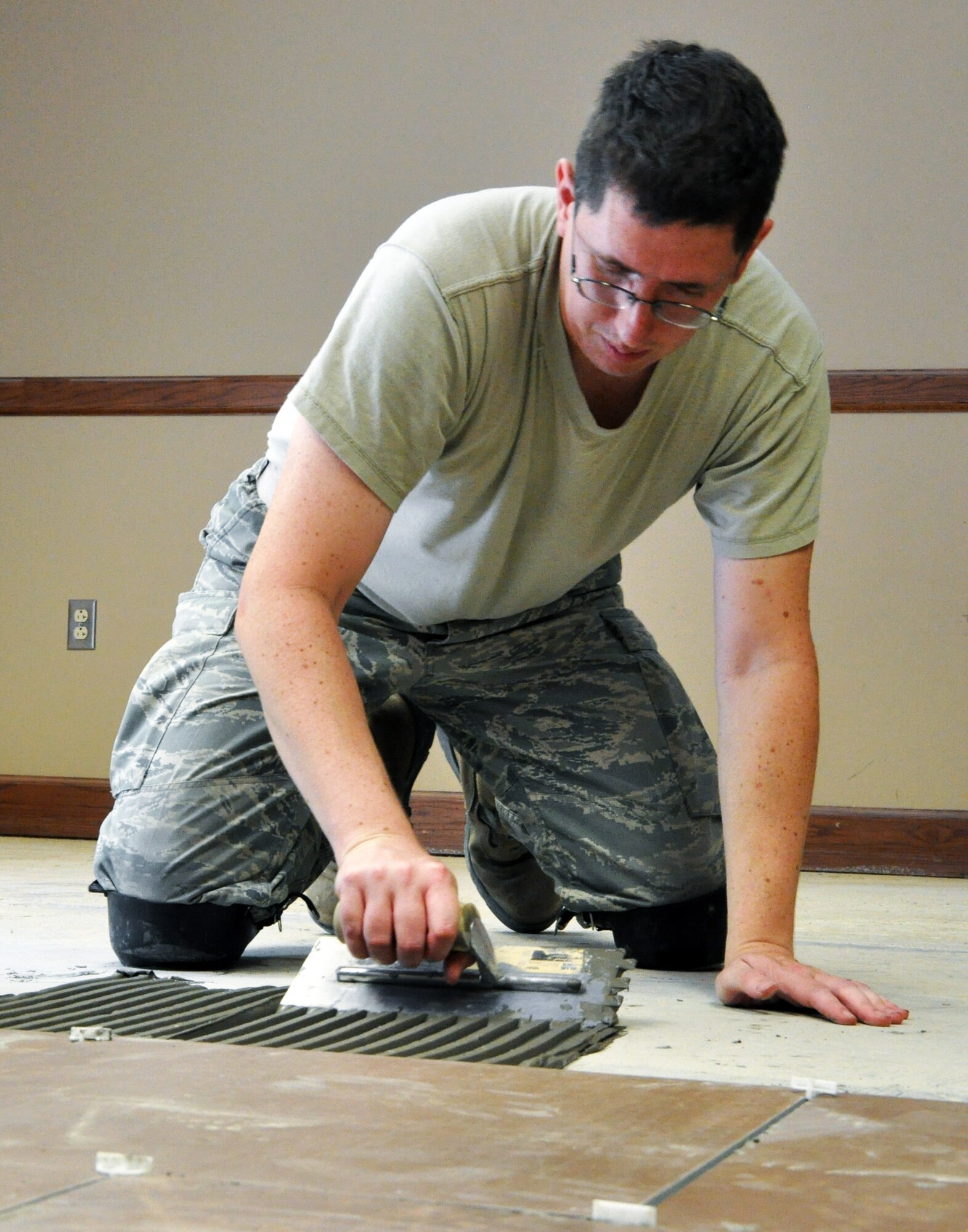 Tech. Sgt. David Brodbeck, 931st Civil Engineer Squadron, spreads mortar for installing floor tiles in Building 1218 at McConnell Air Force Base, Kan., July 11, 2014. James and several other members of the 931 CES spent the July Unit Training Assembly installing new floor tiles in the building as part of a renovation project conducted by Civil Engineer Airmen from both the active-duty 22nd Air Refueling Wing and the Air Force Reserve 931st Air Refueling Group. ). 931 CES Airmen consistently work together with their active duty counterparts from the 22nd Air Refueling Wing to repair and improve the facilities of McConnell Air Force Base. (U.S. Air Force photo by Capt. Zach Anderson)  



