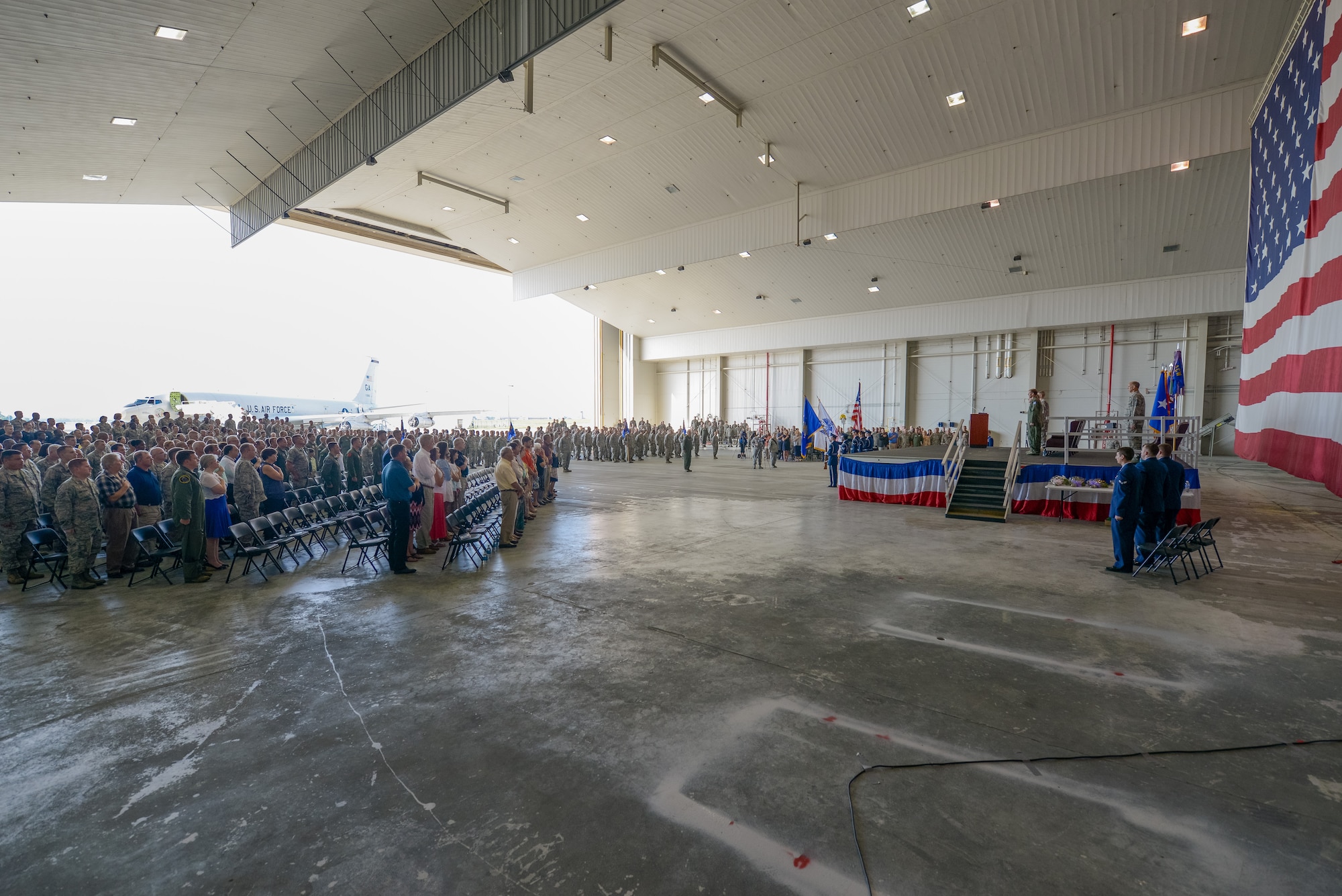 The crowd attending the 116th Air Control Wing (ACW) Change of Command ceremony stands to their feet during the presentation of the colors and singing of the National Anthem at Robins Air Force Base, Ga., July 11, 2015. Col. Mark Weber assumed command of the 116th ACW from Col. Kevin Clotfelter during the ceremony officiated by Brig. Gen. Jesse Simmons Jr., commander, Georgia Air National Guard. The 116th ACW provides manned, joint airborne command and control, battle management, intelligence, surveillance, and reconnaissance support to combatant commanders around the globe flying the E-8C Joint STARS aircraft. (U.S. Air National Guard photo by Senior Master Sgt. Roger Parsons/Released)