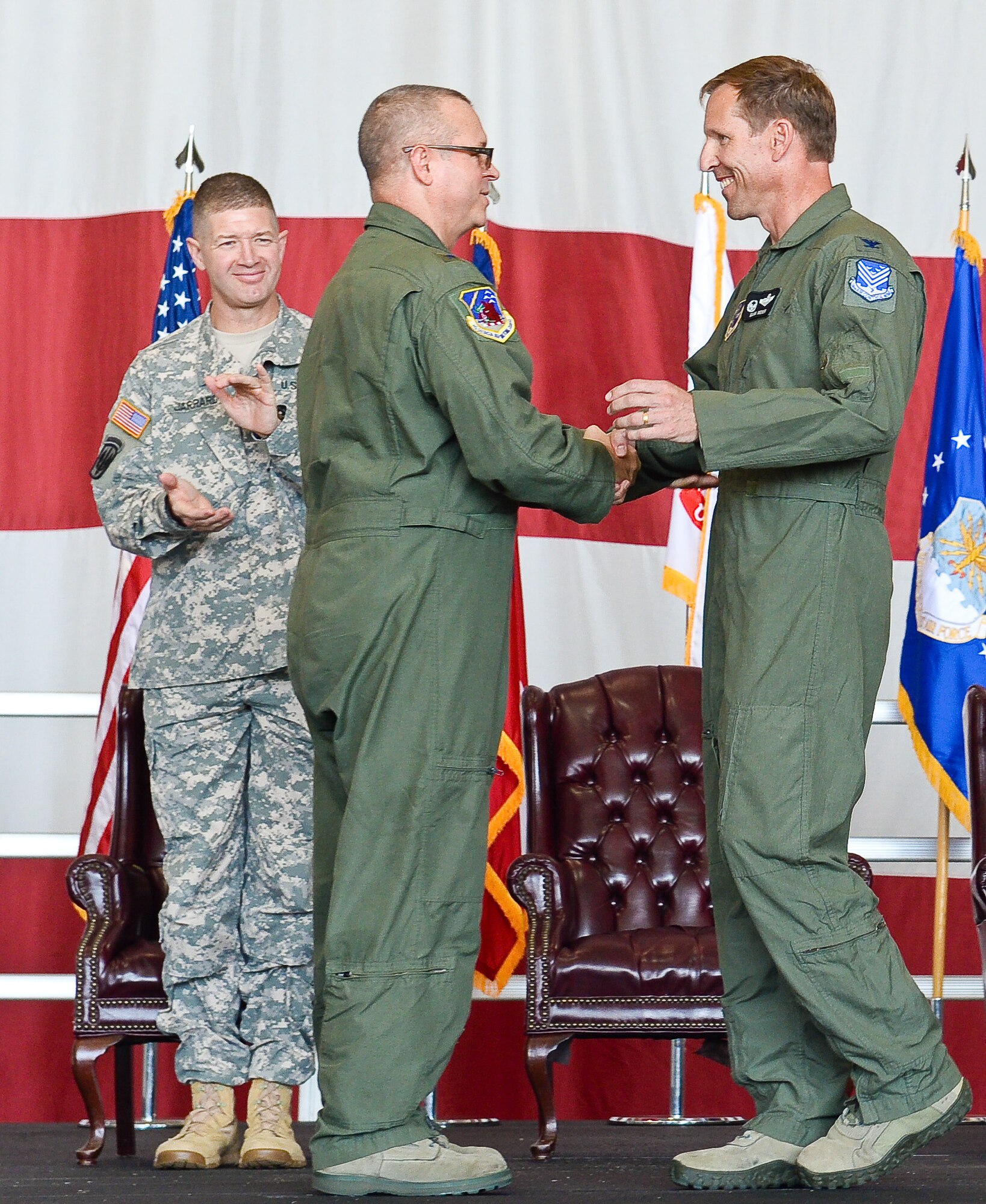 U.S. Air Force Brig. Gen. Jesse Simmons Jr., commander of the Georgia Air National Guard, congratulates Col. Mark Weber on assuming command of the 116th Air Control Wing as U.S. Army Brig. Gen. Joe Jarrard, adjutant general, Georgia Department of Defense, looks on during a Change of Command ceremony at Robins Air Force Base, Ga., July 11, 2015.  Weber assumed command of the 116th ACW from Col. Kevin Clotfelter during a change of command ceremony officiated by Simmons. The 116th ACW provides manned, joint airborne command and control, battle management, intelligence, surveillance, and reconnaissance support to combatant commanders around the globe flying the E-8C Joint STARS aircraft. (U.S. Air National Guard photo by Tech. Sgt. Regina Young/Released)