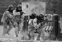 A team of 96th Security Forces Squadron Airmen perform a side-advancing movement during a shoot, move and communicate drill in June at Eglin Air Force Base, Fla.  This mandatory training requirement is in addition to the Airmen's annual weapons qualification training.  The exercise consists of Airmen firing simmunition ammo while advancing toward, away from and to the side of a target.  This is followed by a building sweep and clear drill. Eglin’s security forces personnel protect and defend the main base, facilities, gates, Duke Field, 7th SFG compound and land and water ranges.  (U.S. Air Force photo/Tech. Sgt. Sam King)
