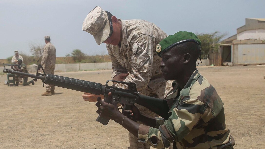 U.S. Marine Cpl. Justin Jones, right, an infantryman with Special-Purpose Marine Air-Ground Task Force Crisis Response-Africa, coaches a member of the Senegalese Compagnie Fusilier de Marin Commandos during a basic skills competition in St. Louis, Senegal, July 2, 2015. More than 15 U.S. Marines and Sailors with the unit held a weapons and combat medical skills competition for more than 30 members of the Fusilier Marins in an effort to build and sustain infantry fundamentals. 
