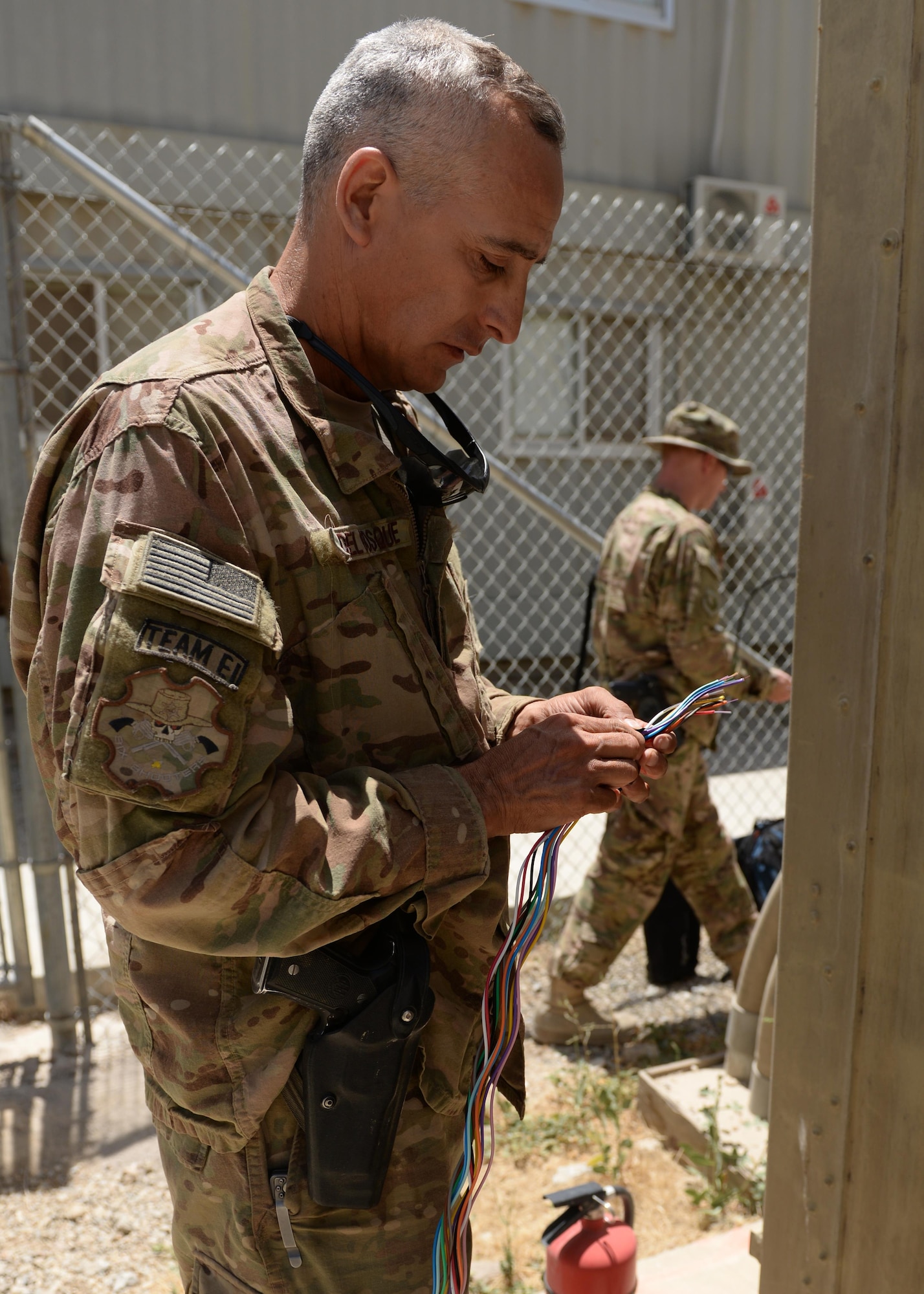 Texas Air National Guard Staff Sgt. Peter Del Bosque, 455th Expeditionary Communication Squadron cable and antenna systems installer, unravels fiber cable July 8, 2015, at Bagram Airfield, Afghanistan. The engineering and installations team is responsible for installing fiber and copper cables throughout the base that impact flying missions and network systems, including NATO communications. (U.S. Air Force photo by Senior Airman Cierra Presentado/Released)