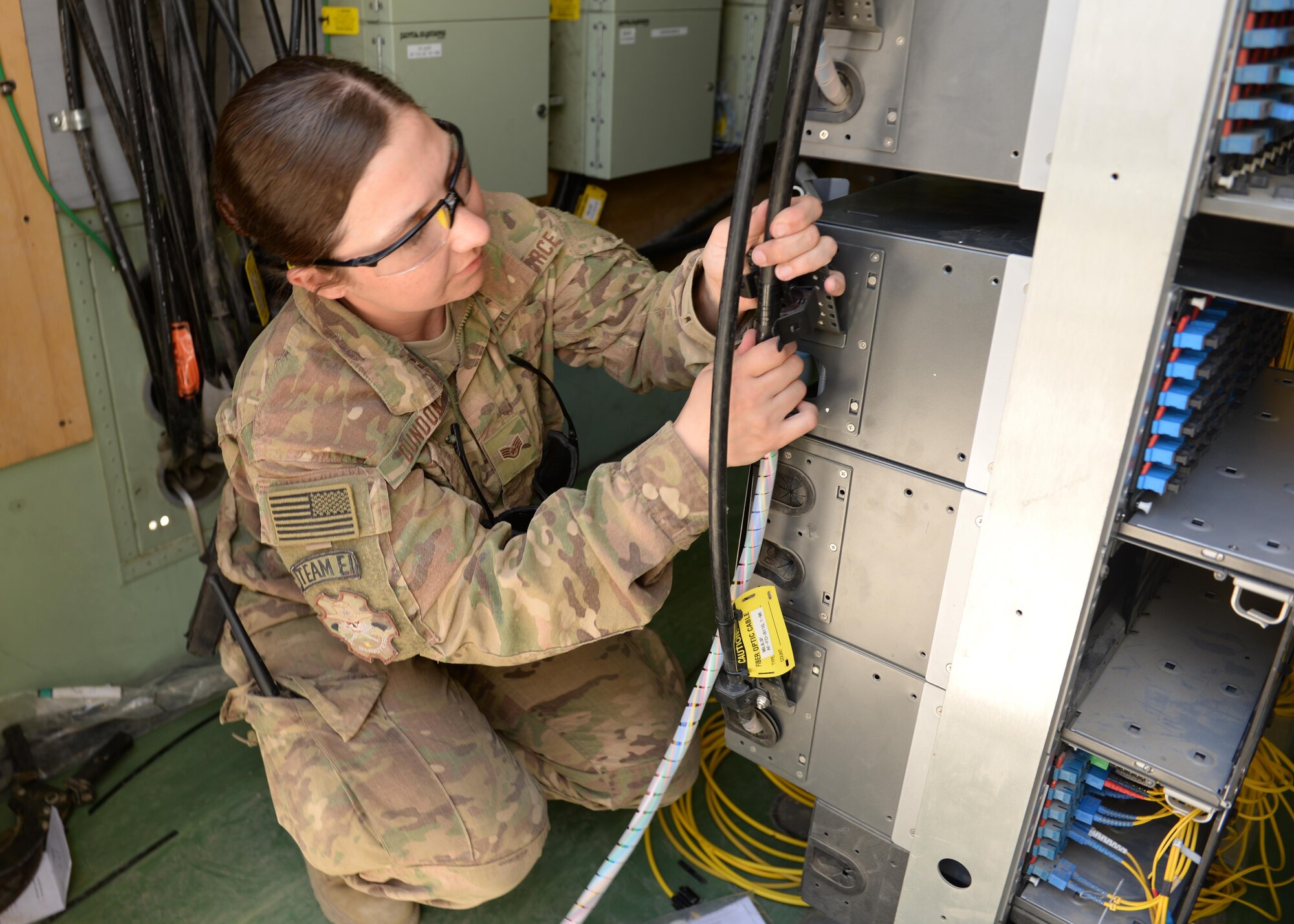 Texas Air National Guard Staff Sgt. Melissa Dundon, 455th Expeditionary Communications Squadron cable and antenna systems installer, helps install a new cable system July 8, 2015, at Bagram Airfield, Afghanistan. The engineering and installations team is responsible for installing fiber and copper cables throughout the base that impact flying missions and network systems, including NATO communications. (U.S. Air Force photo by Senior Airman Cierra Presentado/Released)
