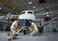 Senior Airman Kevin Kahn, and Airman Mario Hill, 919th Special Operations Maintenance Group, connect a tow bar onto a C-145 June 6 at Duke Field, Fla. The 919th SOMXG is comprised of 919th SOMXS, 919th SOAMXS, 919th SOMOF, and the 592nd SOAMXS. Their primary mission is the maintenance of the C-145 aircraft. (U.S. Air Force photo/Tech. Sgt. Sam King)
