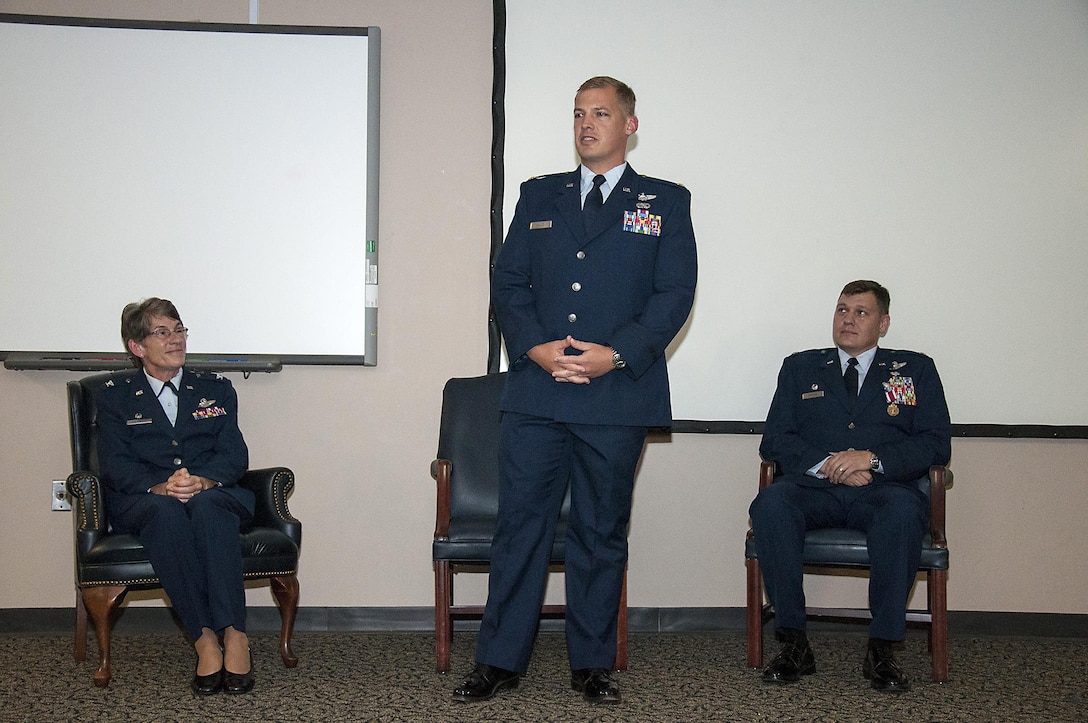 Maj. John D. Ramsey, III shares his comments after taking command of the 315th Airlift Control Flight this past Unit Training Assembly. Col. Caroline Evernham, 315th Operations Group commander, and Lt. Col. Don Thigpen, II sit on stage behind him. (U.S. Air Force Photo by Staff Sgt. Bobby Pilch)