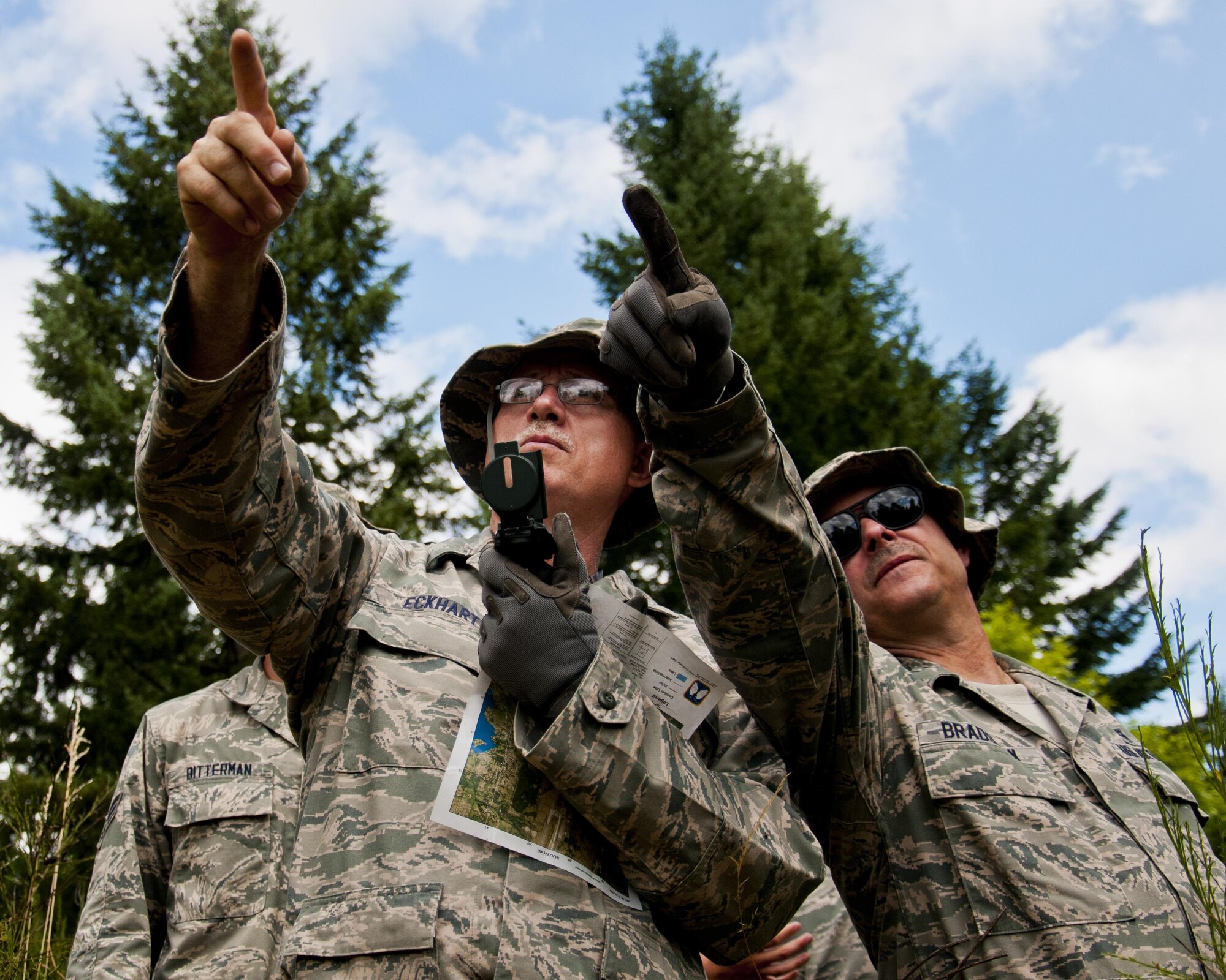 Medics from the 446th Aeromedical Staging Squadron discern which direction to head for land navigation training during the Care Under Fire exercise at Joint Base Lewis-McChord, July 12, 2015. The Care Under Fire exercise was designed locally by the 446th ASTS in order to simulate combat conditions and establish team oriented training scenarios. Medics were offered land navigation training in order to enhance their combat readiness in austere locations. (U.S. Air Force photo by Senior Airman Daniel Liddicoet/