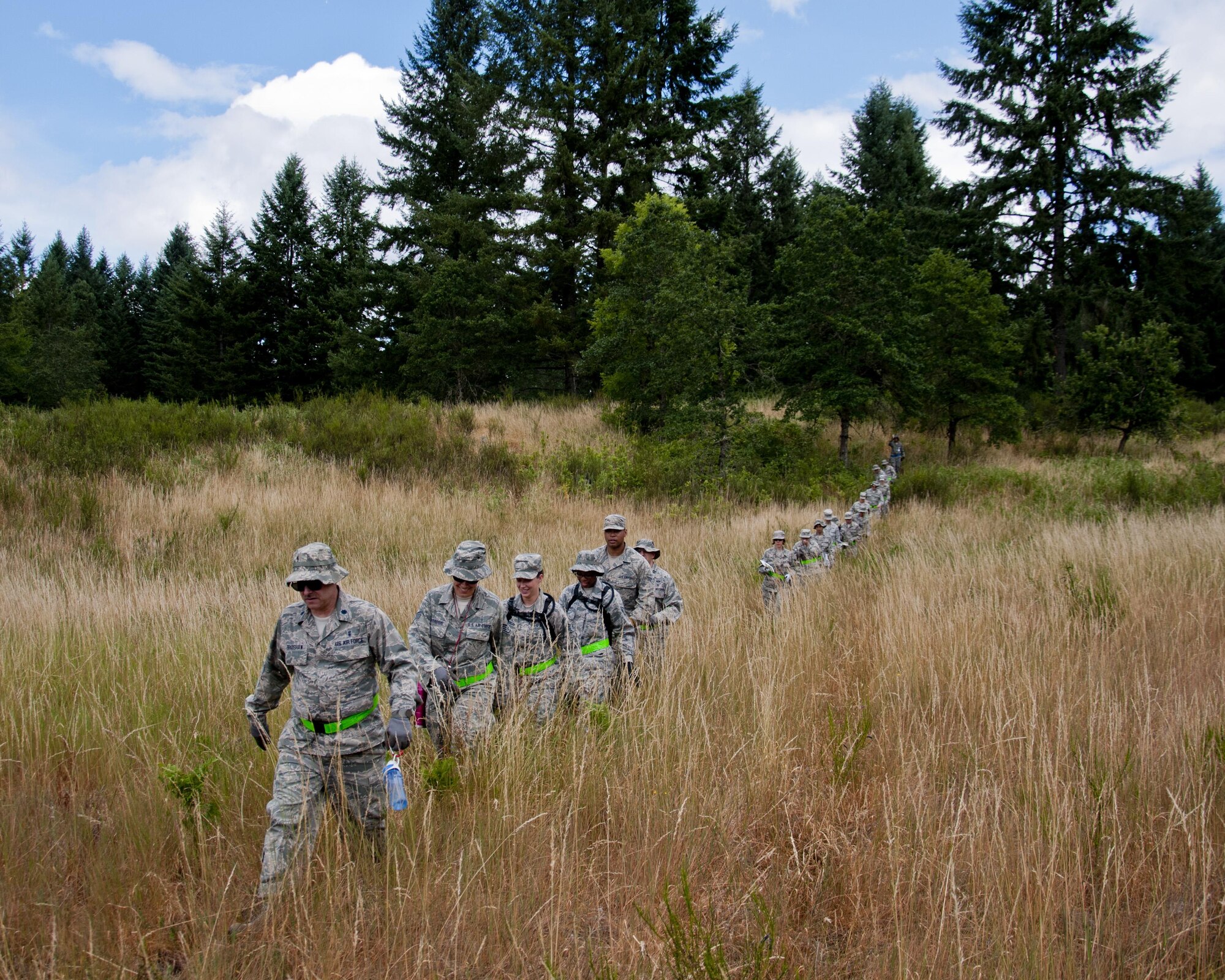 Medics from the 446th Aeromedical Staging Squadron make their way through the woods for the Care Under Fire exercise at Joint Base Lewis-McChord, July 12, 2015. The Care Under Fire exercise was designed locally by the 446th ASTS in order to simulate combat conditions and establish team oriented training scenarios. Medics were offered land navigation training in order to enhance their combat readiness in austere locations. (U.S. Air Force photo by Senior Airman Daniel Liddicoet)