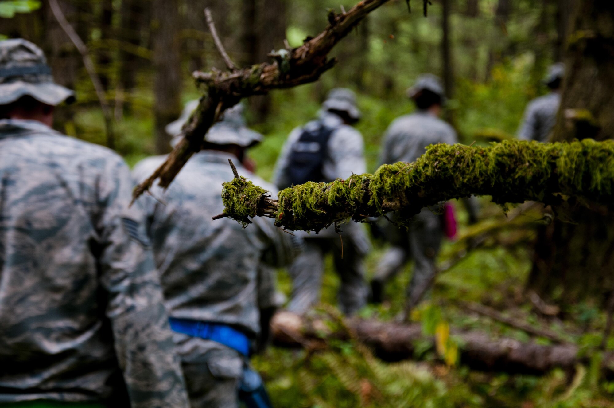 Medics from the 446th Aeromedical Staging Squadron make their way through the woods for the Care Under Fire exercise at Joint Base Lewis-McChord, July 12, 2015. The Care Under Fire exercise was designed locally by the 446th ASTS in order to simulate combat conditions and establish team oriented training scenarios. Medics were offered land navigation training in order to enhance their combat readiness in austere locations. (U.S. Air Force photo by Senior Airman Daniel Liddicoet/Released)
