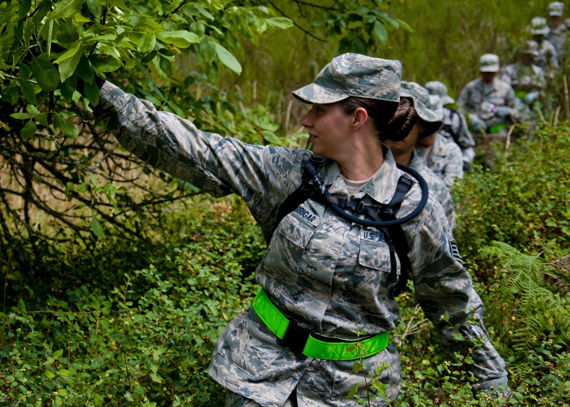 Medics from the 446th Aeromedical Staging Squadron make their way through the woods for the Care Under Fire exercise at Joint Base Lewis-McChord, July 12, 2015. The Care Under Fire exercise was designed locally by the 446th ASTS in order to simulate combat conditions and establish team oriented training scenarios. Medics were offered land navigation training in order to enhance their combat readiness in austere locations. (U.S. Air Force photo by Senior Airman Daniel Liddicoet)