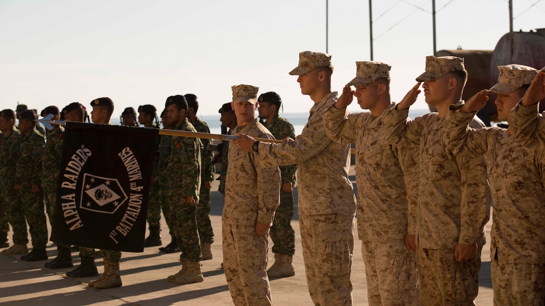 A platoon of U.S. Marines with Company A, 1st Battalion, 4th Marine Regiment, Marine Rotational Force – Darwin and Timor-Leste Defence Force members salute during the opening ceremony of Exercise Koa Moana 15.2 in Dili, Timor-Leste, June 22. The platoon of U.S. Marines conducted the bilateral exercise with one platoon of the Timor-Leste Defence Force’s naval force and one platoon of their Marines, focusing on the fundamentals of squad and platoon-level tasks. The exercise allows the Marines to train with one another’s country and provides the opportunity to learn about their history, growth and development as a military force and experience a different culture.