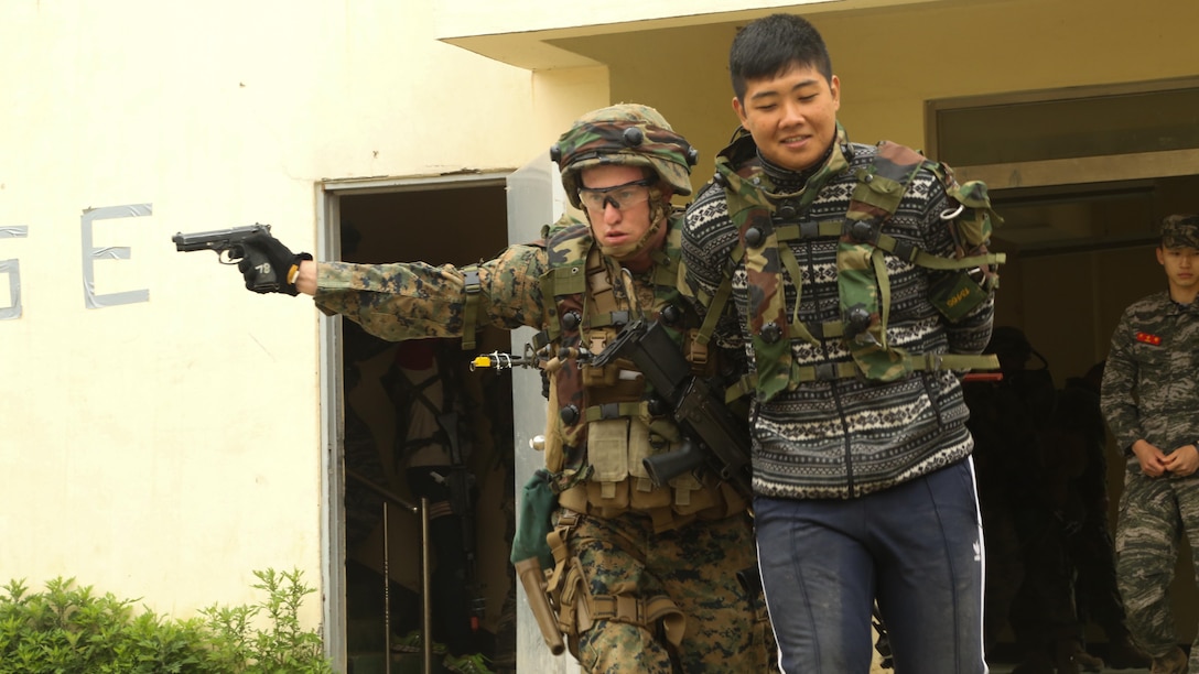 U.S. Marine Corps Lance Cpl. Bruce Beard escorts a high profile target to a detainee retention center during the culminating event of Korean Marine Exchange Program 15-11 in Pohang, Republic of Korea, May 16, 2015. KMEP 15-11 is focused on exchanging law enforcement techniques, tactics and procedures while enhancing relations across the Korean Peninsula. Beard is a military policeman with Alpha Company, 3rd Law Enforcement, III Marine Expeditionary Force Headquarters Group, III MEF. 