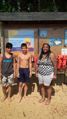 From left to right: Jose Sigran, Jafet Aguiler and Alexandria Gunter pose in front a loaner lifejacket stand on Lake Hartwell June 3. Gunter volunteered to swim lifejackets to the boys who were stranded on a buoy after becoming winded attempting to swim back to the shoreline