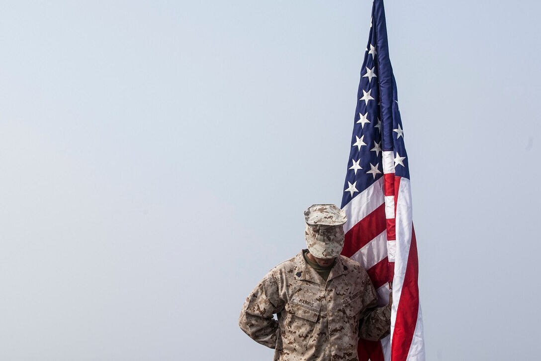 ARABIAN GULF (July 4, 2015) U.S. Marine Sgt. Leclair Harris holds the American Flag during an Independence Day ceremony aboard the dock landing ship USS Rushmore (LSD 47). Harris is a combat engineer with Combat Logistics Battalion 15, 15th Marine Expeditionary Unit. Marines with CLB- 15, 15th MEU, read the Declaration of Independence in observation of the Fourth of July and later celebrated with an American style barbeque on the flight deck. The 15th MEU is embarked on the Essex Amphibious Ready Group and deployed to maintain regional security in the U.S. 5th Fleet area of operations. (U.S. Marine Corps photo by Sgt. Emmanuel Ramos/Released)