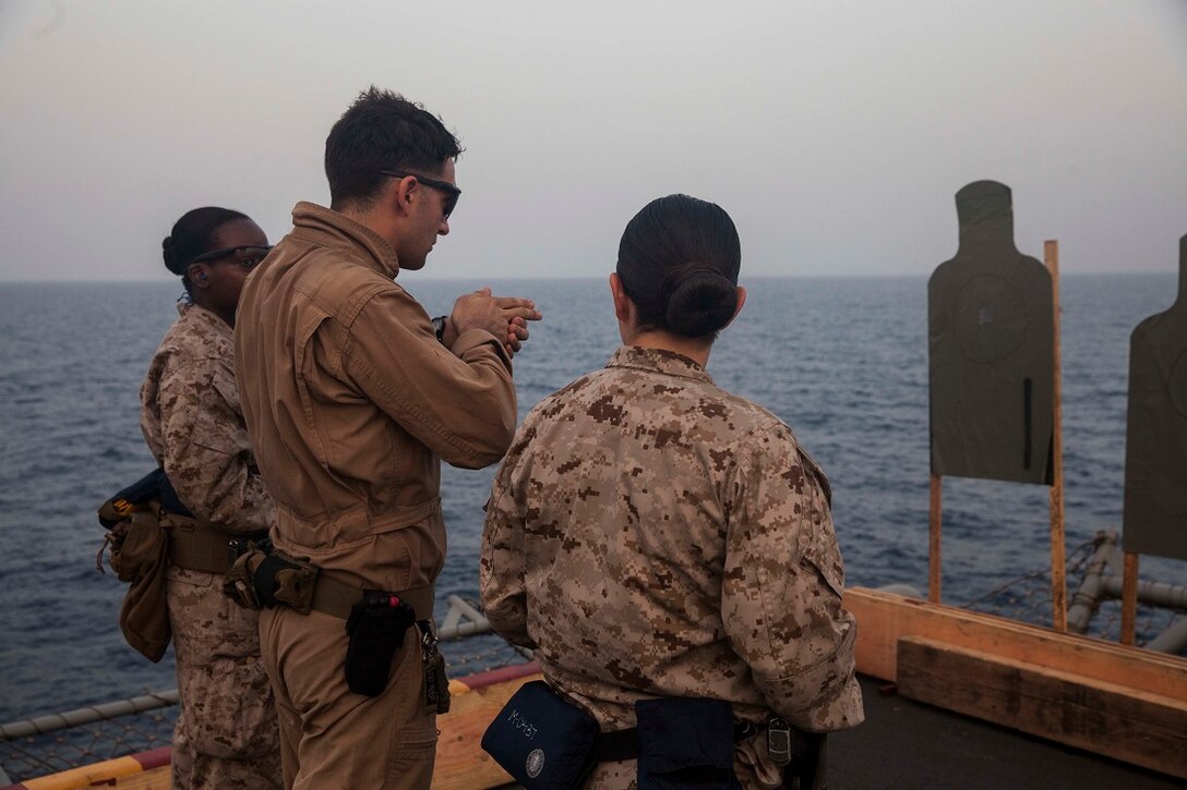 GULF OF ADEN (July 8, 2015) U.S. Marine Sgt. Sean Bernstein, middle, explains pistol fundamentals to Marines with the 15th Marine Expeditionary Unit. Bernstein is a member of the 15th MEU’s Maritime Raid Force. He was teaching Marines who were participating in a week-long screener how to become a member of a Female Engagement Team. The 15th MEU is embarked aboard the Essex Amphibious Ready Group and deployed to maintain regional security in the U.S. 5th Fleet area of operations. (U.S. Marine Corps photo by Cpl. Anna Albrecht/Released)
